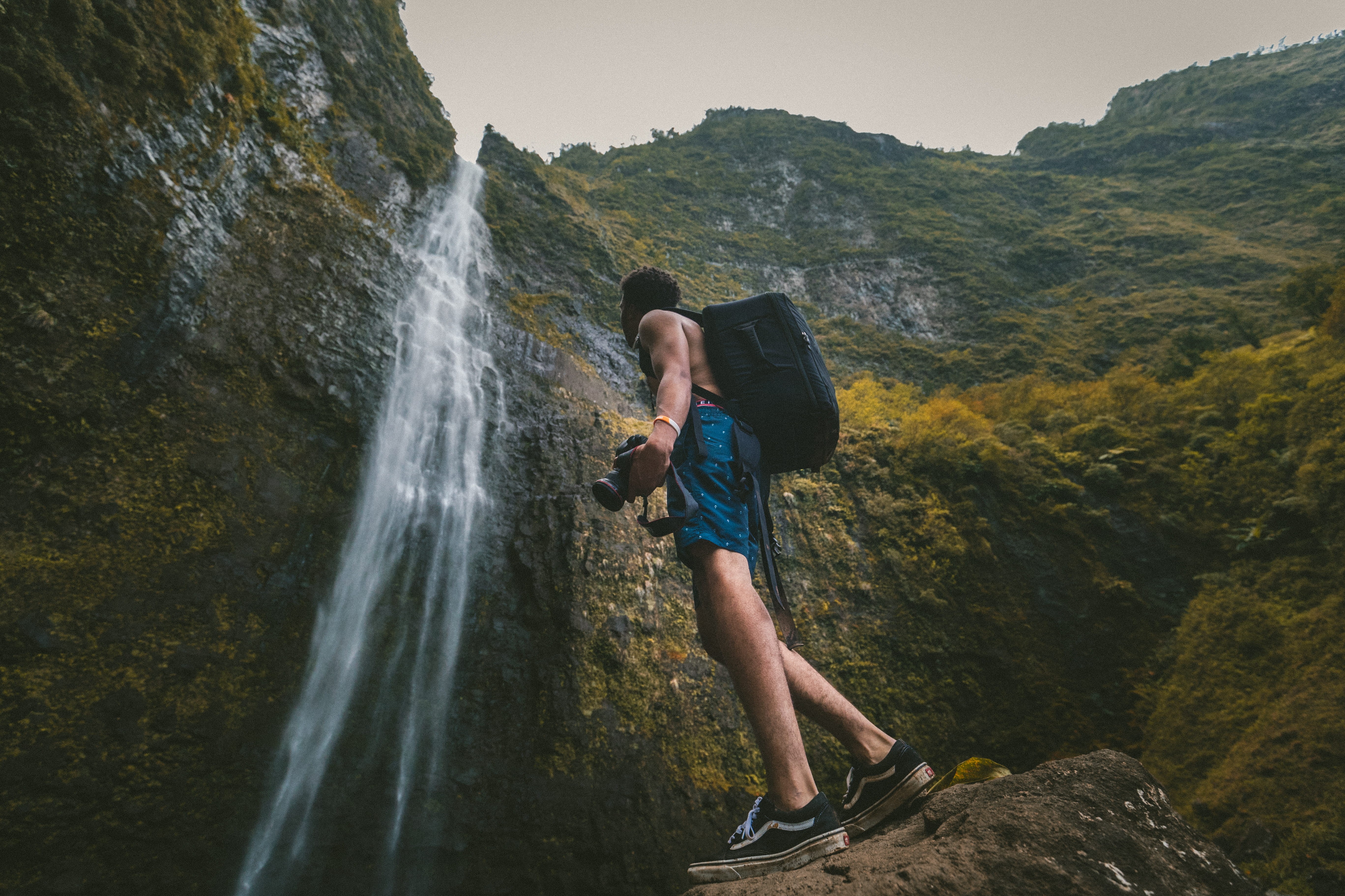 dslr, outdoors, camera, one Person, rock, holding, formation, young adult, Waterfall, landscape, recreational Pursuit, real people, healthy Lifestyle, nature, HD Wallpaper