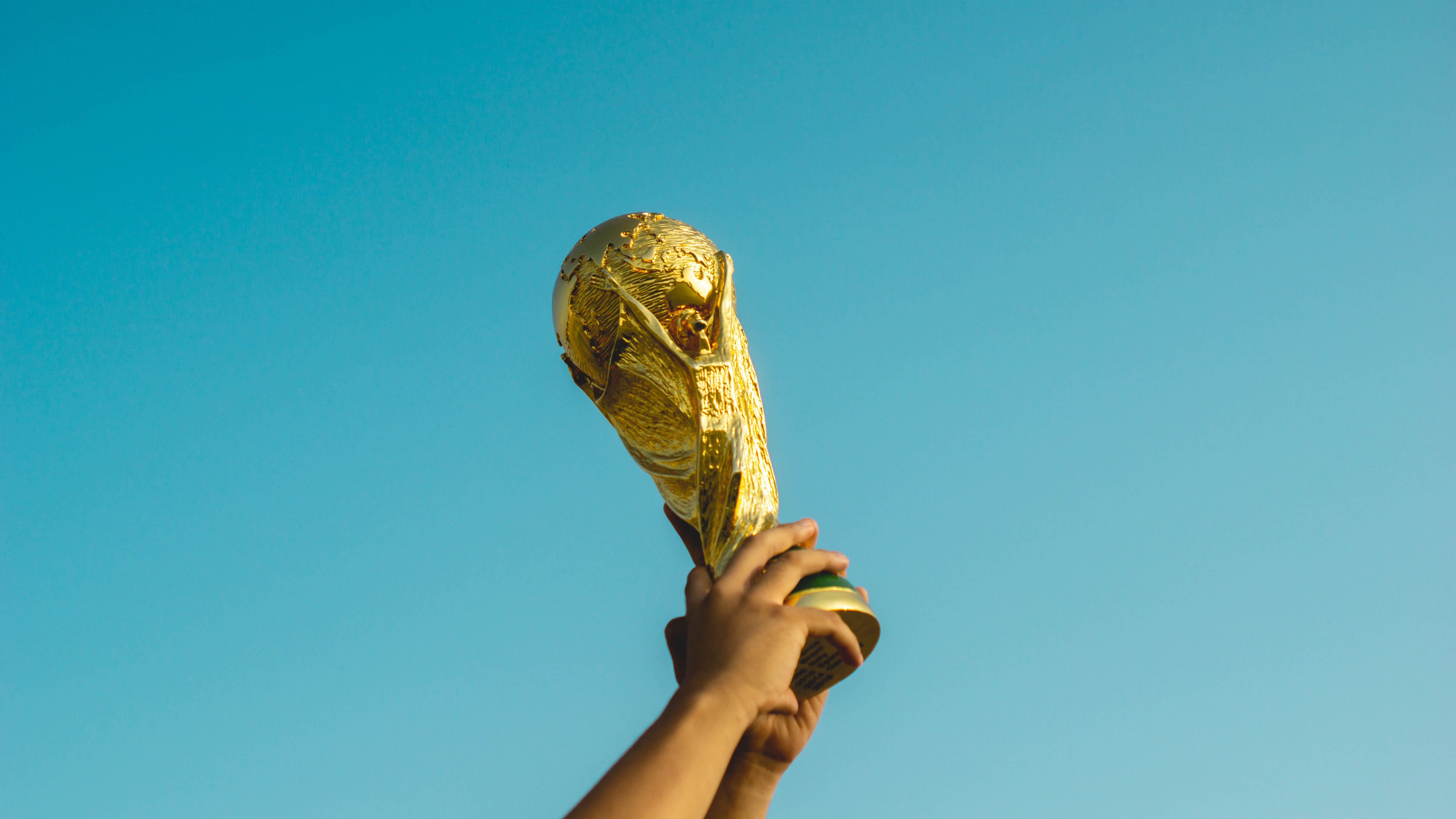 colored background, gold, unrecognizable person, football, world cup, low angle view, champion, sky, food and drink, pre world cup, hand, fifa, raising, HD Wallpaper