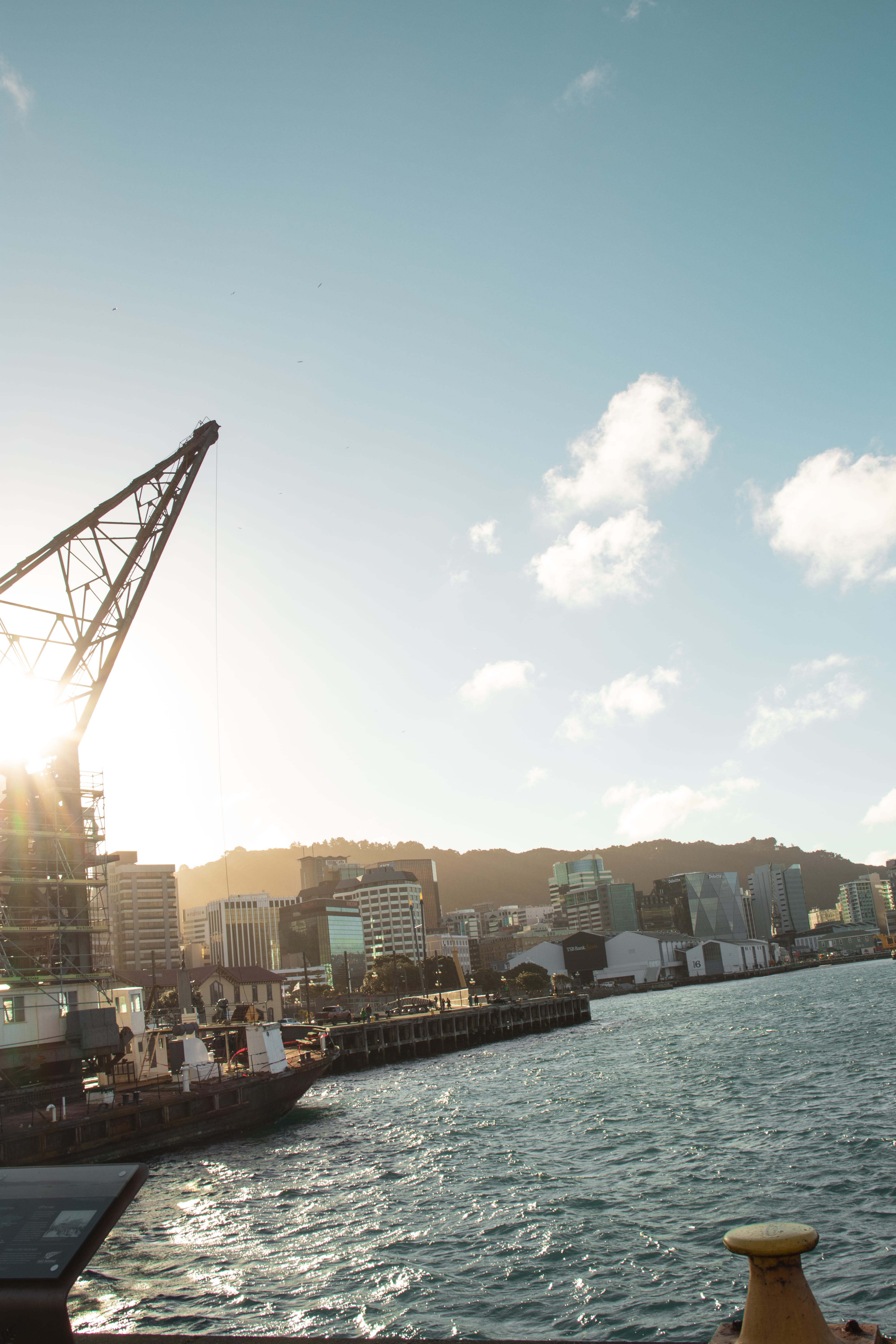 crane - construction machinery, building exterior, buildings, city, light, sun, no people, river, waterfront, clouds, ocean, sea, sunset, outdoors, new zealand, Phone HD Wallpaper