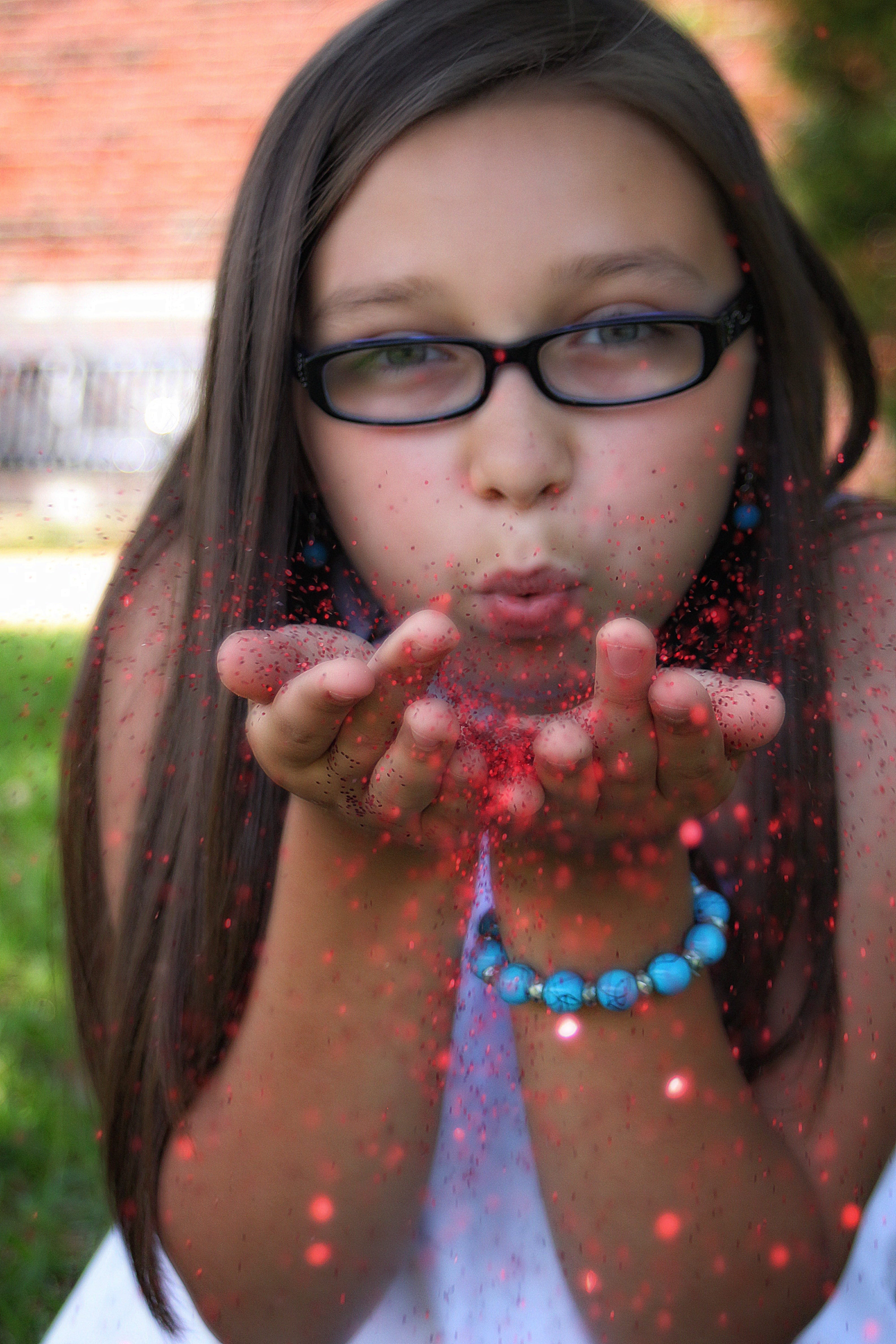caucasian Ethnicity, fun, people, women, innocence, face, blowing, happiness, cute, one Person, girls, young Adult, red glitter, eyeglasses, glitter, glasses, Phone HD Wallpaper