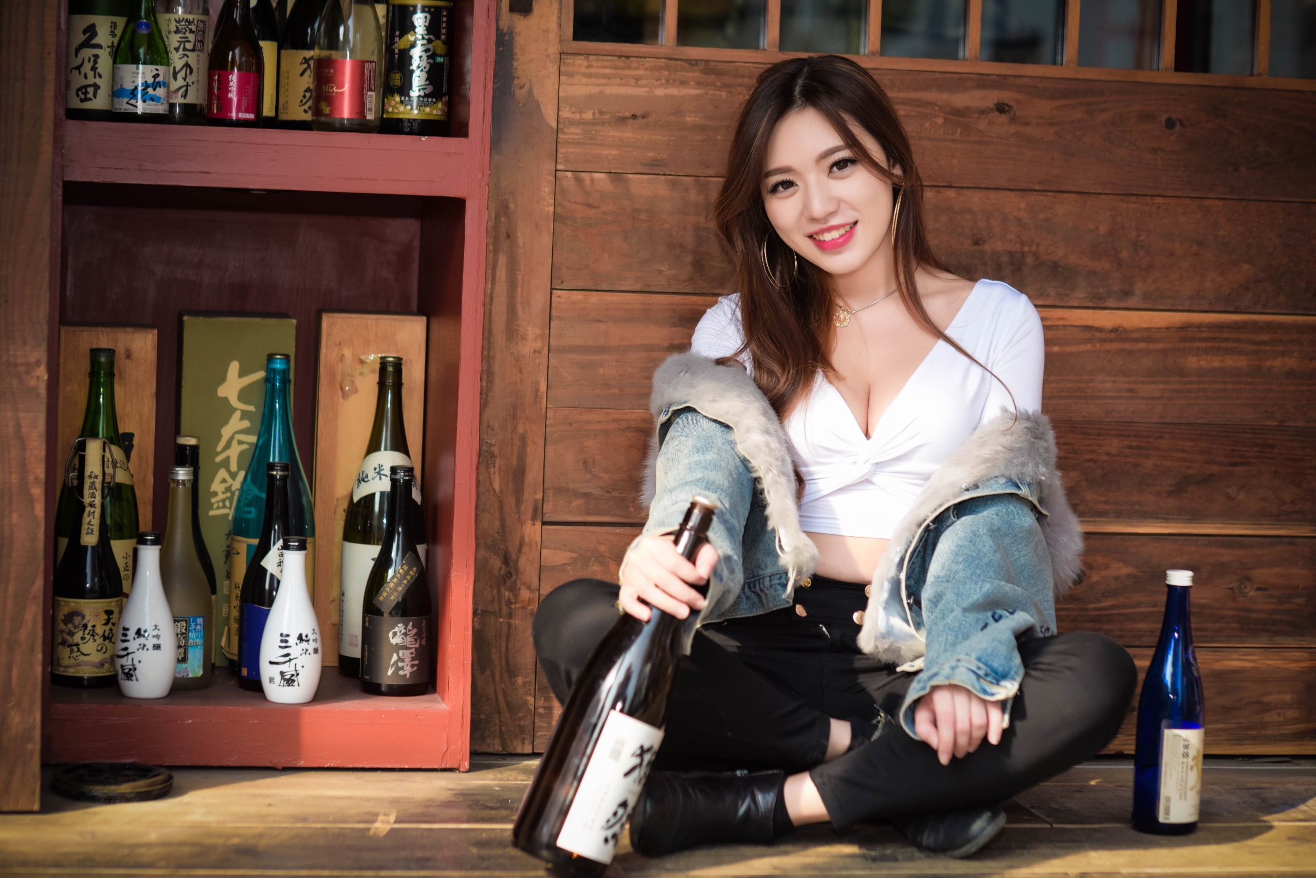 necklace, black pants, sitting, women, jacket, brown eyes, long hair, jeans jacket, looking at viewer, 2K, model, jeans, red lipstick, smiling, cleavage, HD Wallpaper