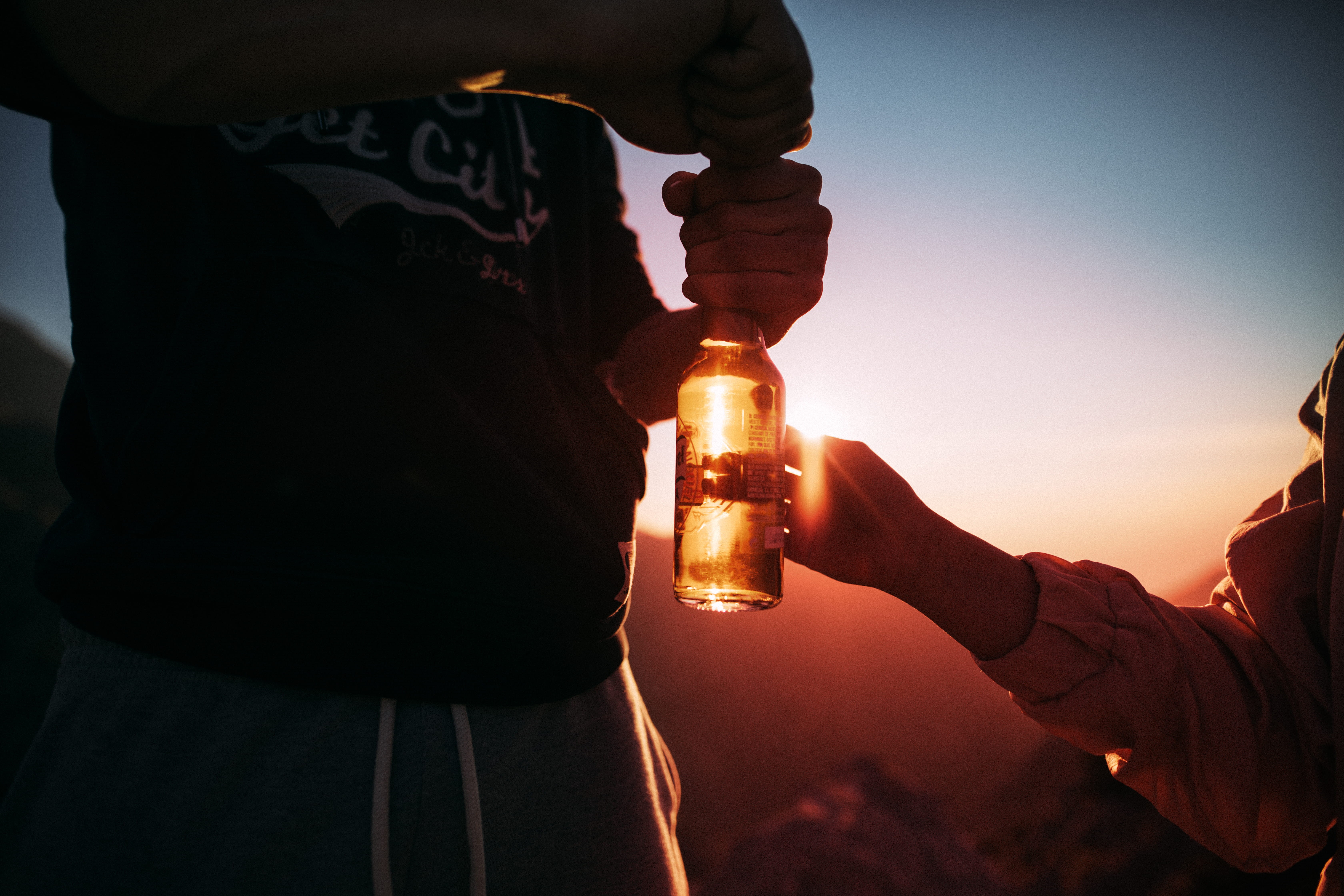glass, beer bottle, bottle, person, real people, near, sunset, sky, refreshment, outdoors, human hand, night, man, glass bottle, beer - Alcohol, food and drink, HD Wallpaper
