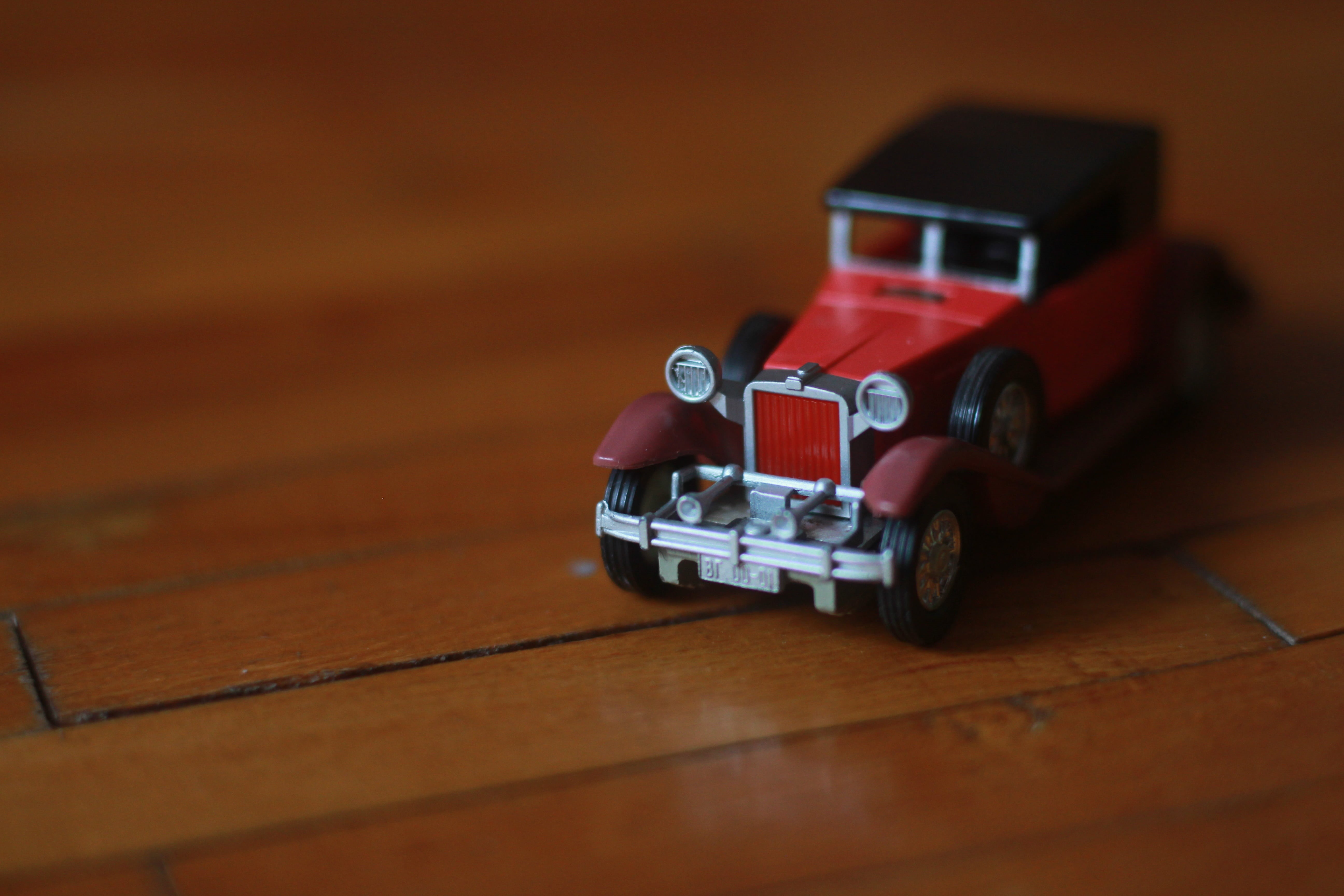 toy, red car, selective focus, wood, indoors, table, childhood, toy block, no people, motor vehicle, mode of transportation, close-up, small, day, flooring, HD Wallpaper