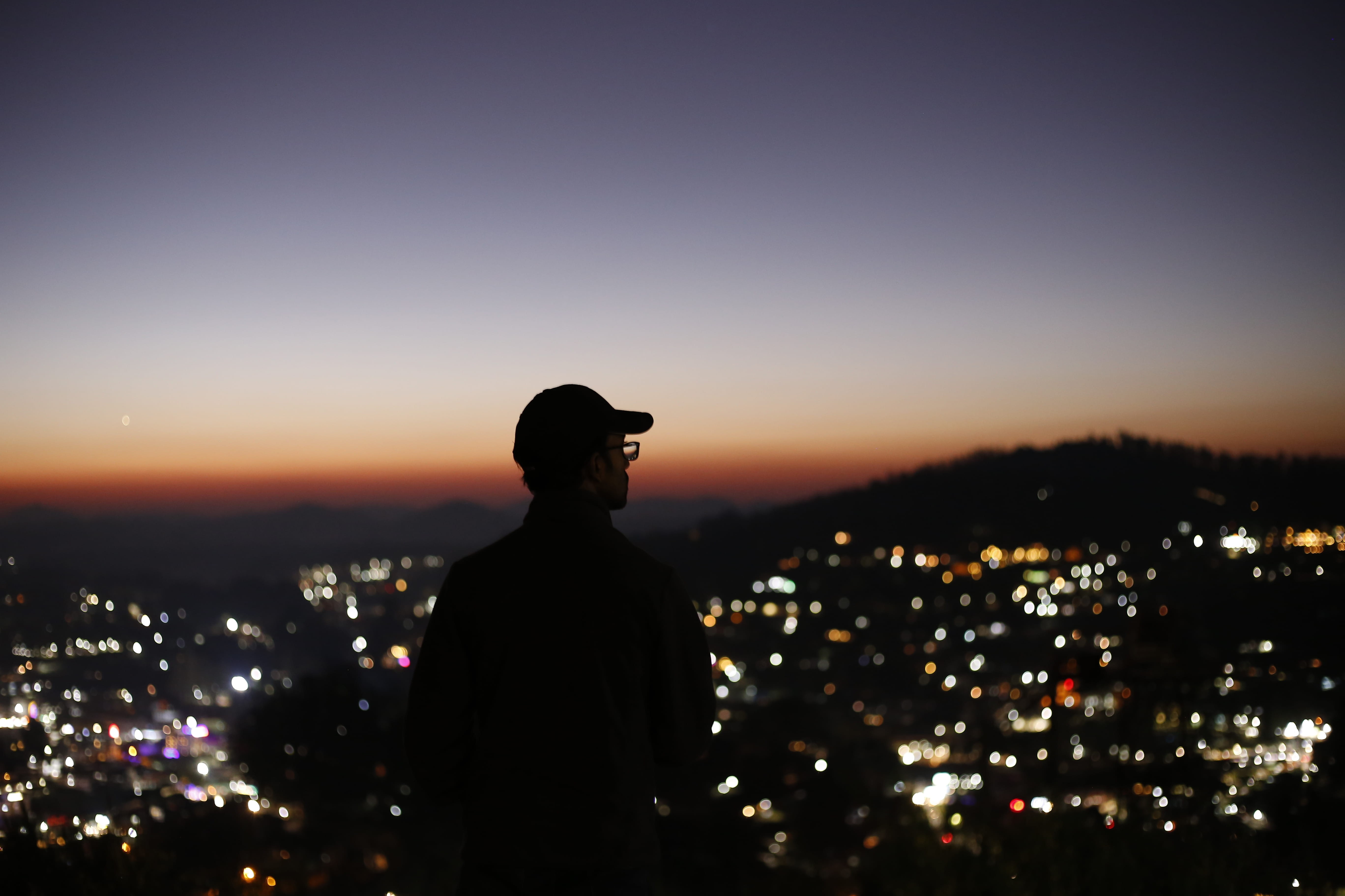 night, sunrise, illuminated, cityscape, city, standing, guy, blur, silhouette, one person, built structure, dark, architecture, nature, male, crowded, leisure activity, HD Wallpaper