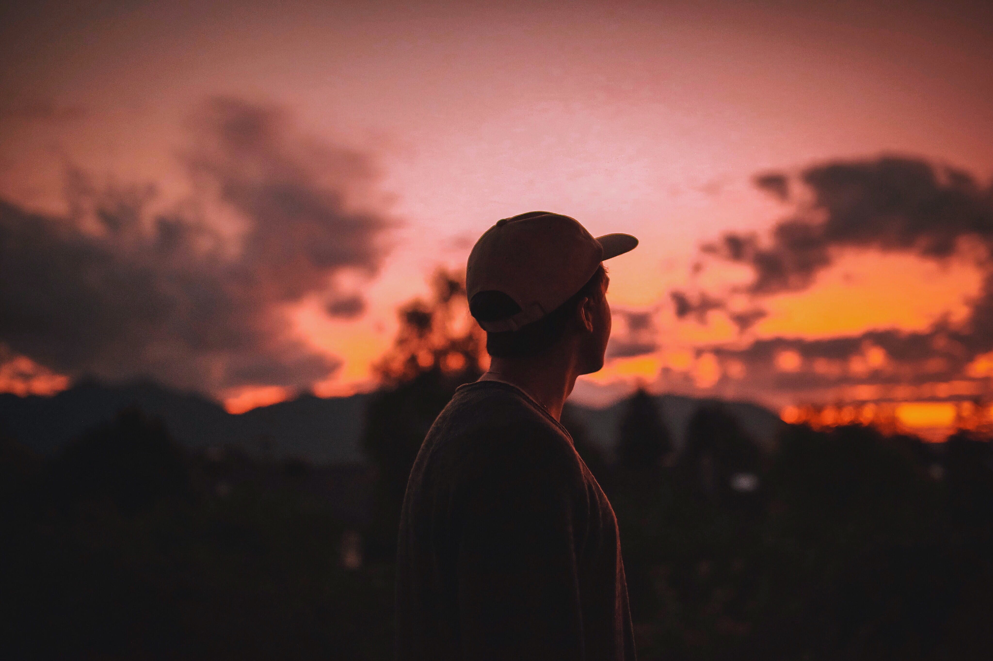 waist up, adult, dusk, backlit, dawn, men, light, orange color, beauty in nature, nature, real people, person, sky, rear view, one person, headshot, sunset, HD Wallpaper
