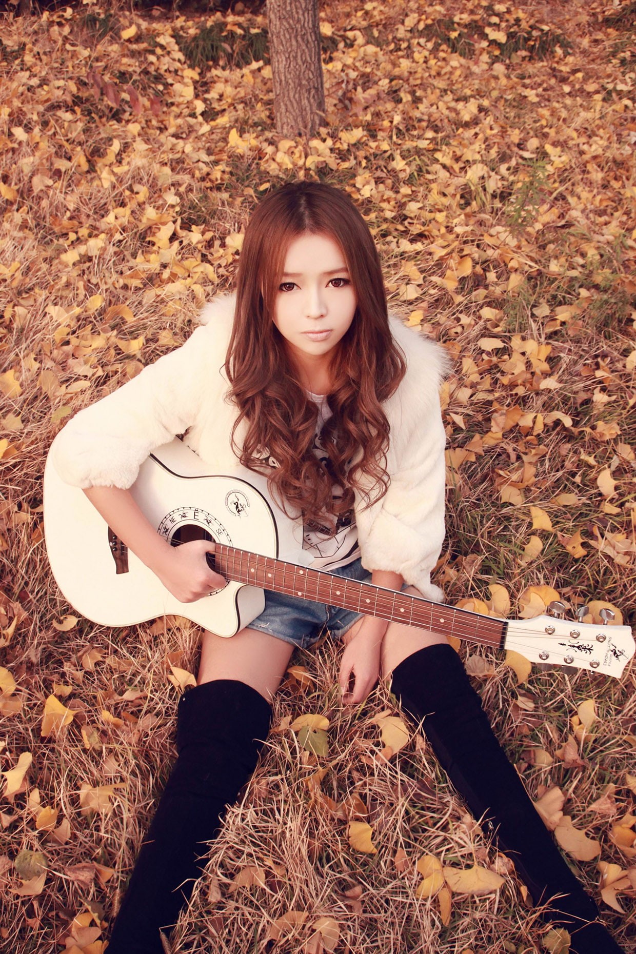720P, real people, one person, looking at camera, model, sitting, day, jean shorts, front view, women outdoors, fallen leaves, musical instrument, young adult, Phone HD Wallpaper