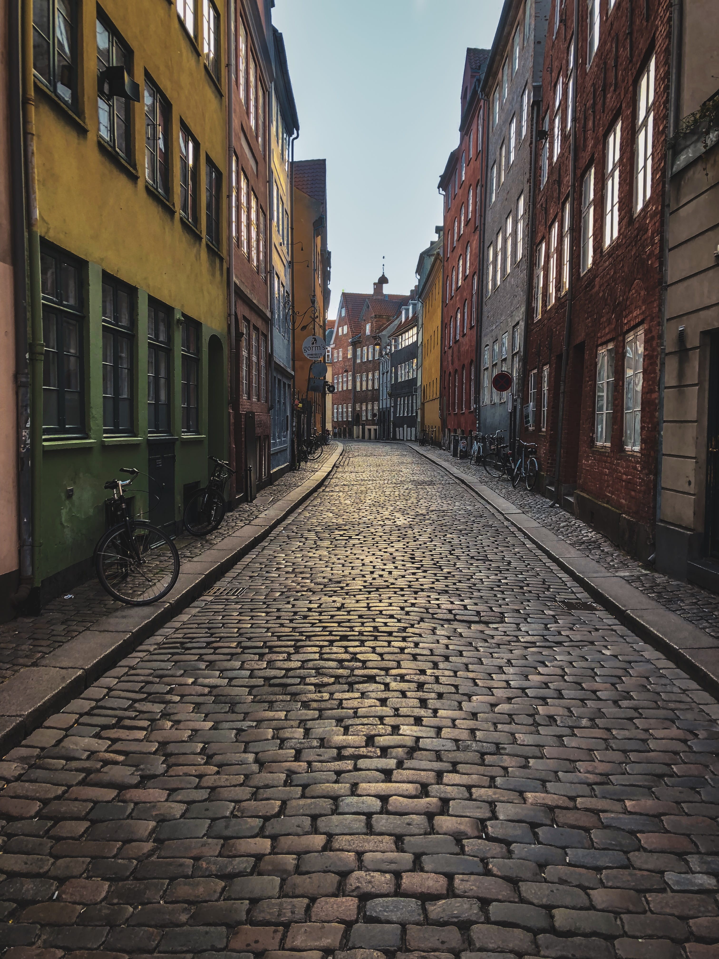 pavement, vehicle, neighborhood, train, alley, sky, walkway, residential district, path, cobblestone, urban, day, city, wheel, footpath, parked, diminishing perspective, Phone HD Wallpaper