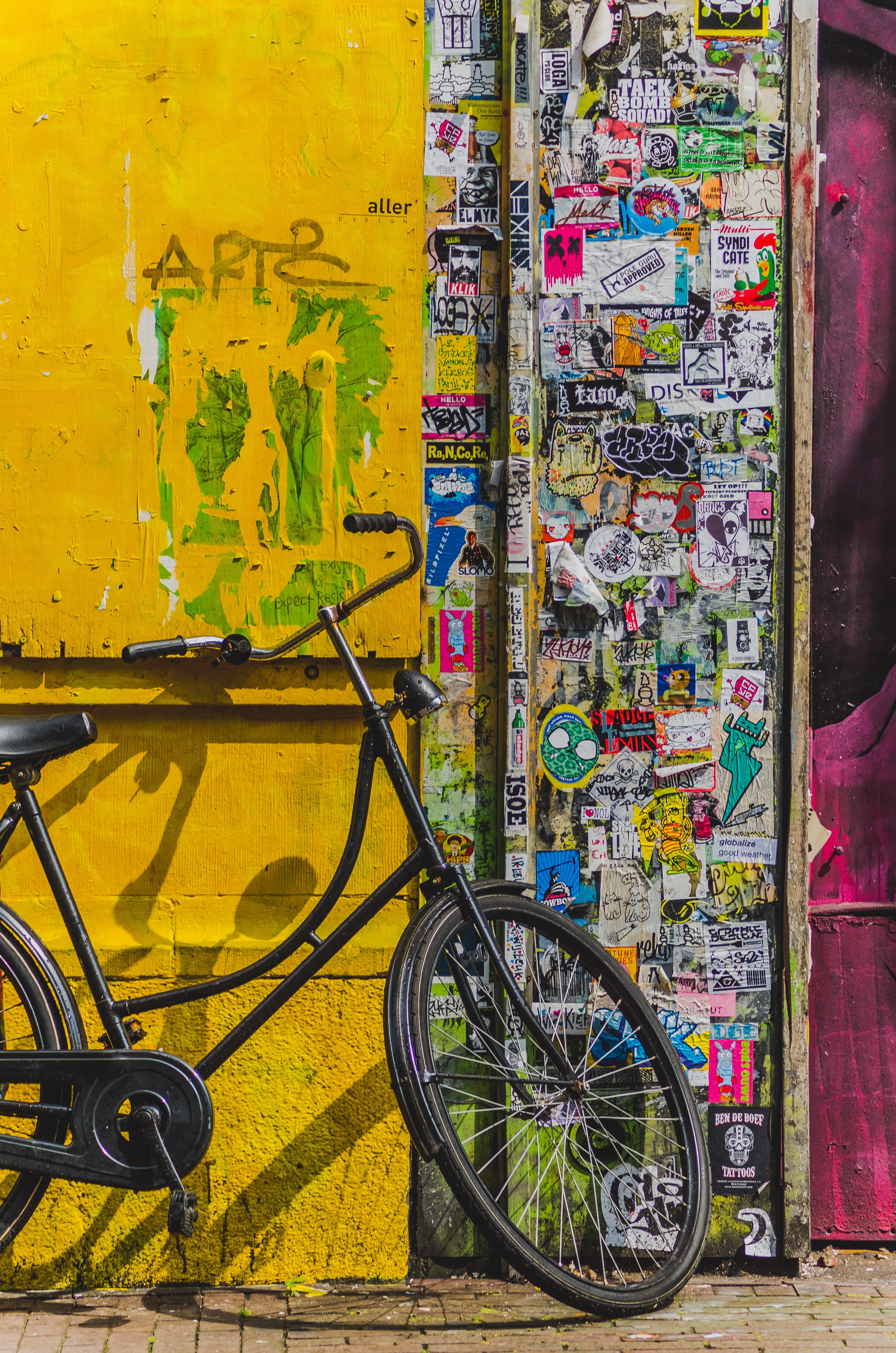 stationary, wall - building feature, 4K, street, outdoors, stickers, day, city, bicycle, multi colored, black, no people, bike, yellow, wheel, transportation, Phone HD Wallpaper