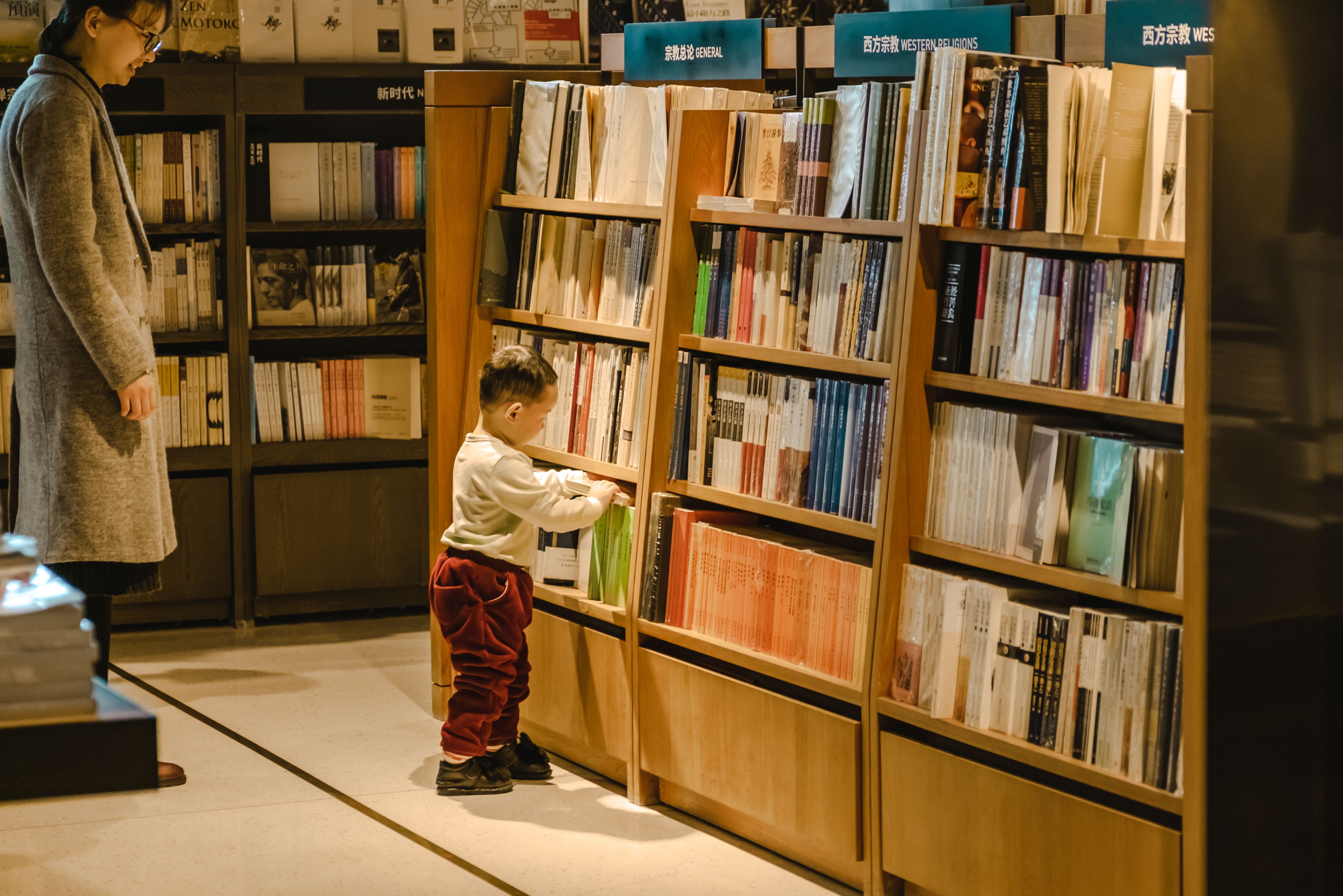 furniture, bookcase, wood, kindergarten, shelf, living room, indoors, publication, human, standing, child, flooring, men, lighting, chair, learning, library, HD Wallpaper