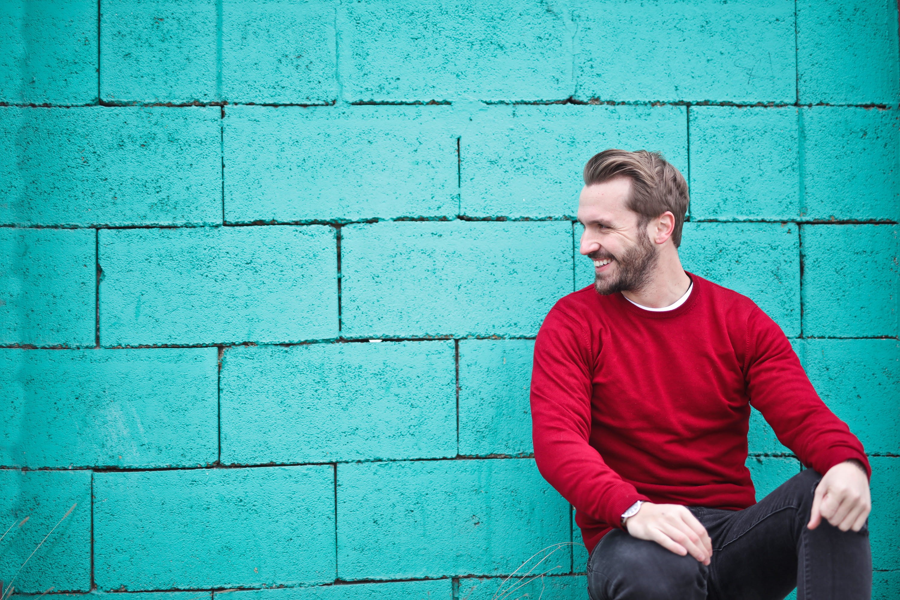 male, Smiling, beard, young men, young adult, man, Sitting, modern, red sweater, sit, sweater, 30-35 years old, wearing, caucasian, black pants, outdoor, HD Wallpaper