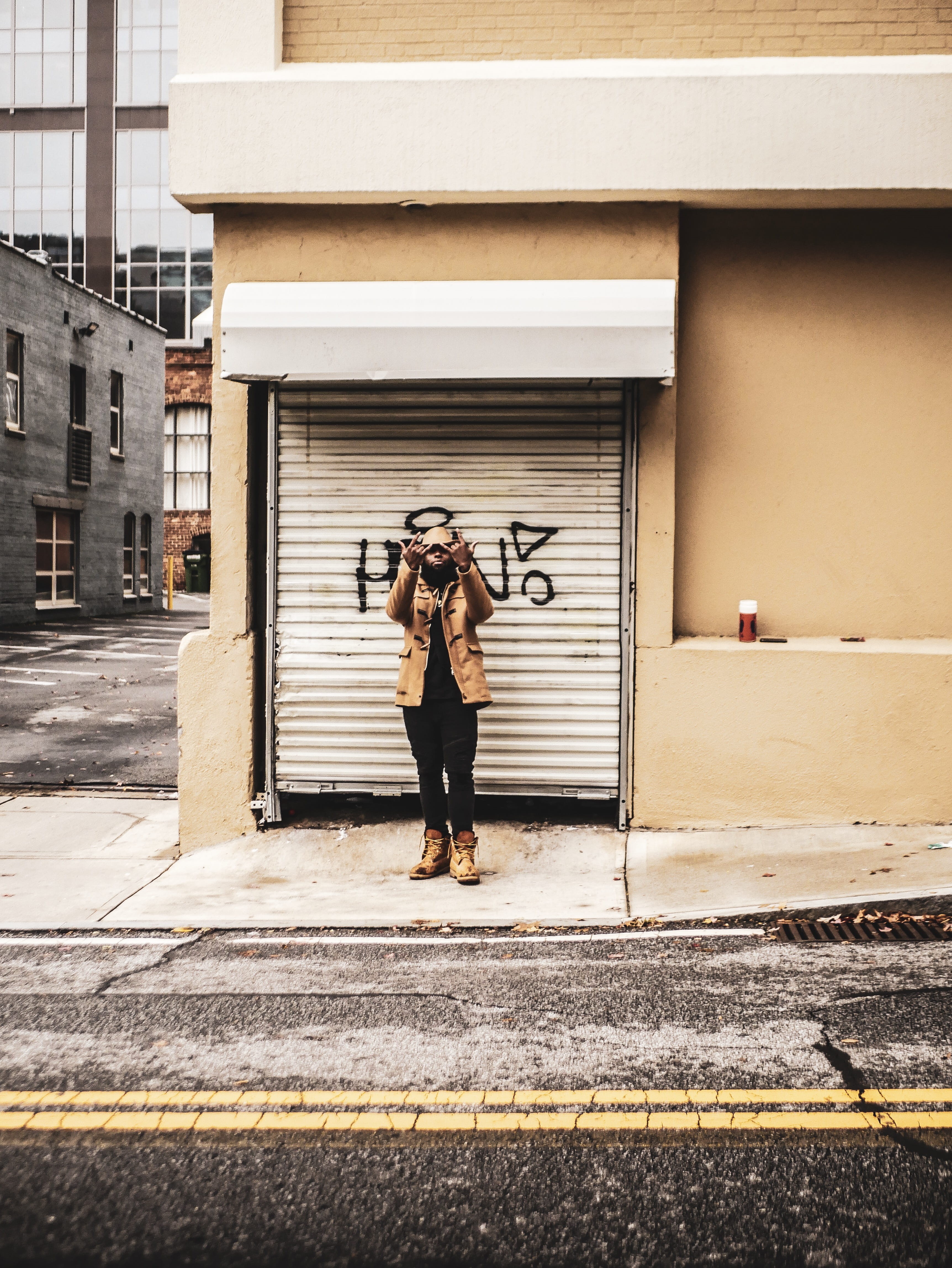 leisure activity, city, urban, posing, male, hand sign, street, women, building, model, one person, asphalt, front view, sidewalk, day, real people, fashionable, Phone HD Wallpaper