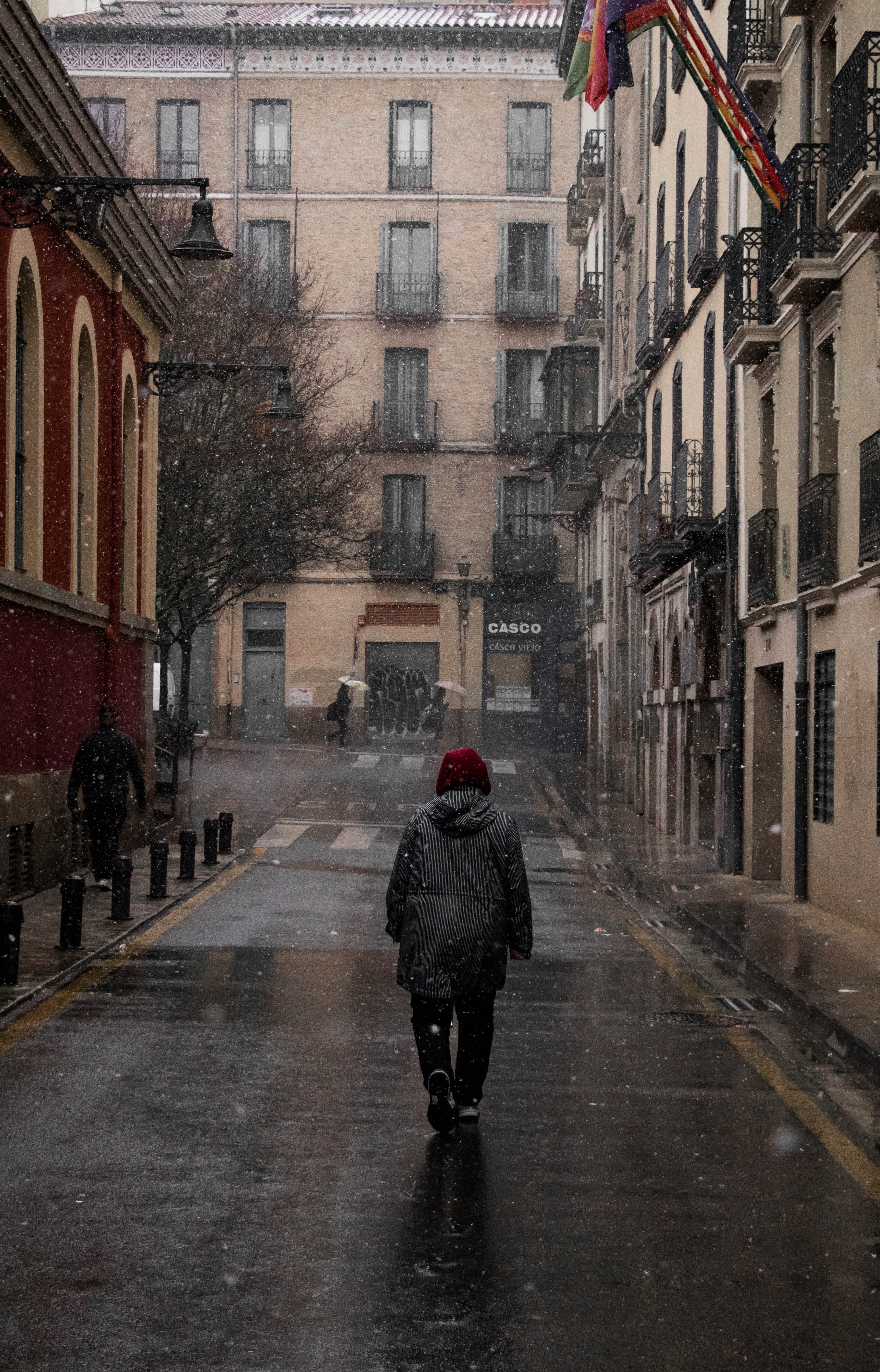 snowstorm, built structure, hoodie, one person, men, full length, snowing, outdoors, rear view, umbrella, winter, building, real people, wet, city, building exterior, Phone HD Wallpaper