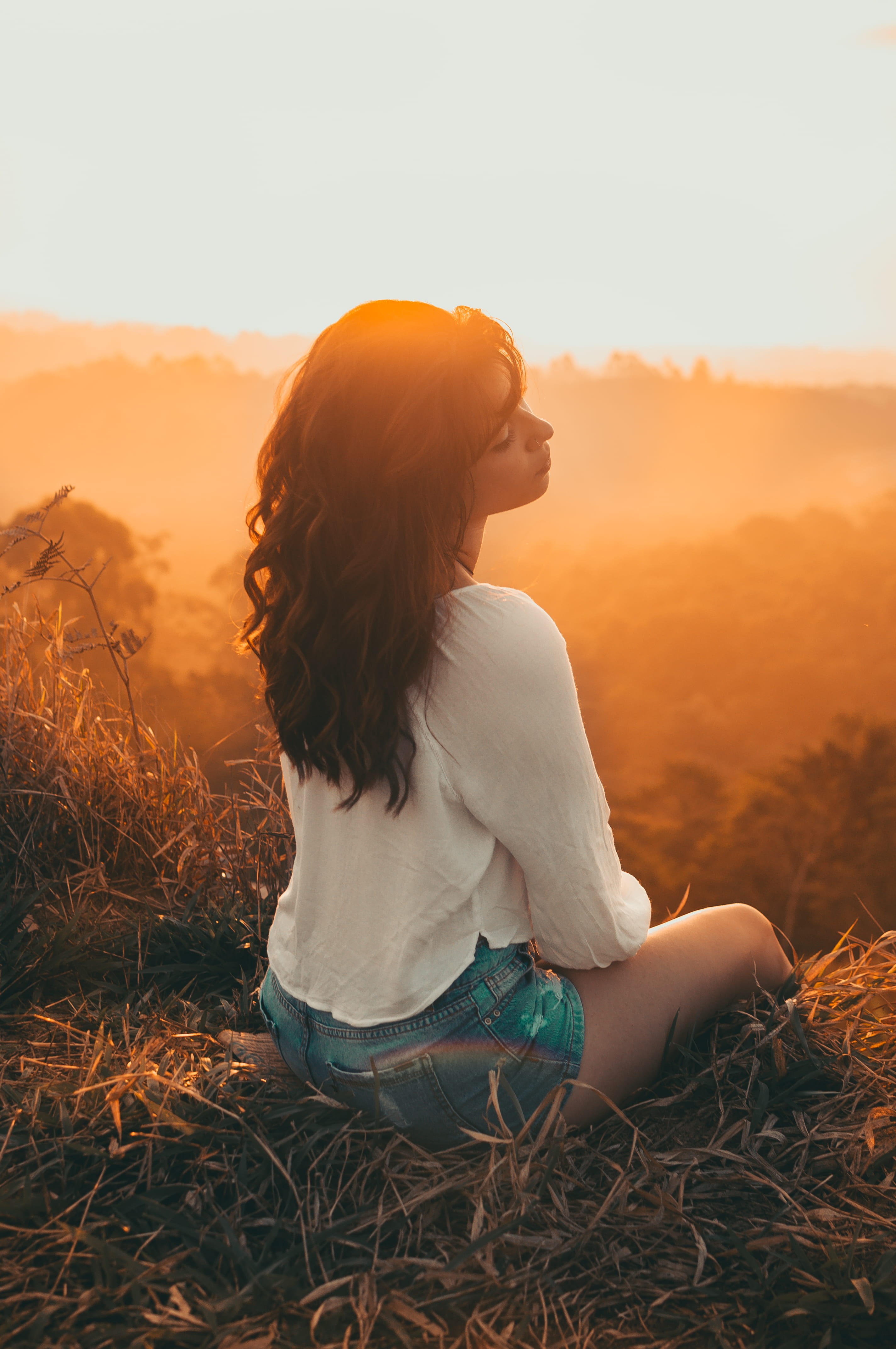 long hair, girl, fashion, beauty in nature, shorts, sun, nature, young women, sunset, sleeved, blur, orange, ray of sunshine, sitting, 4K, hour, long, Phone HD Wallpaper