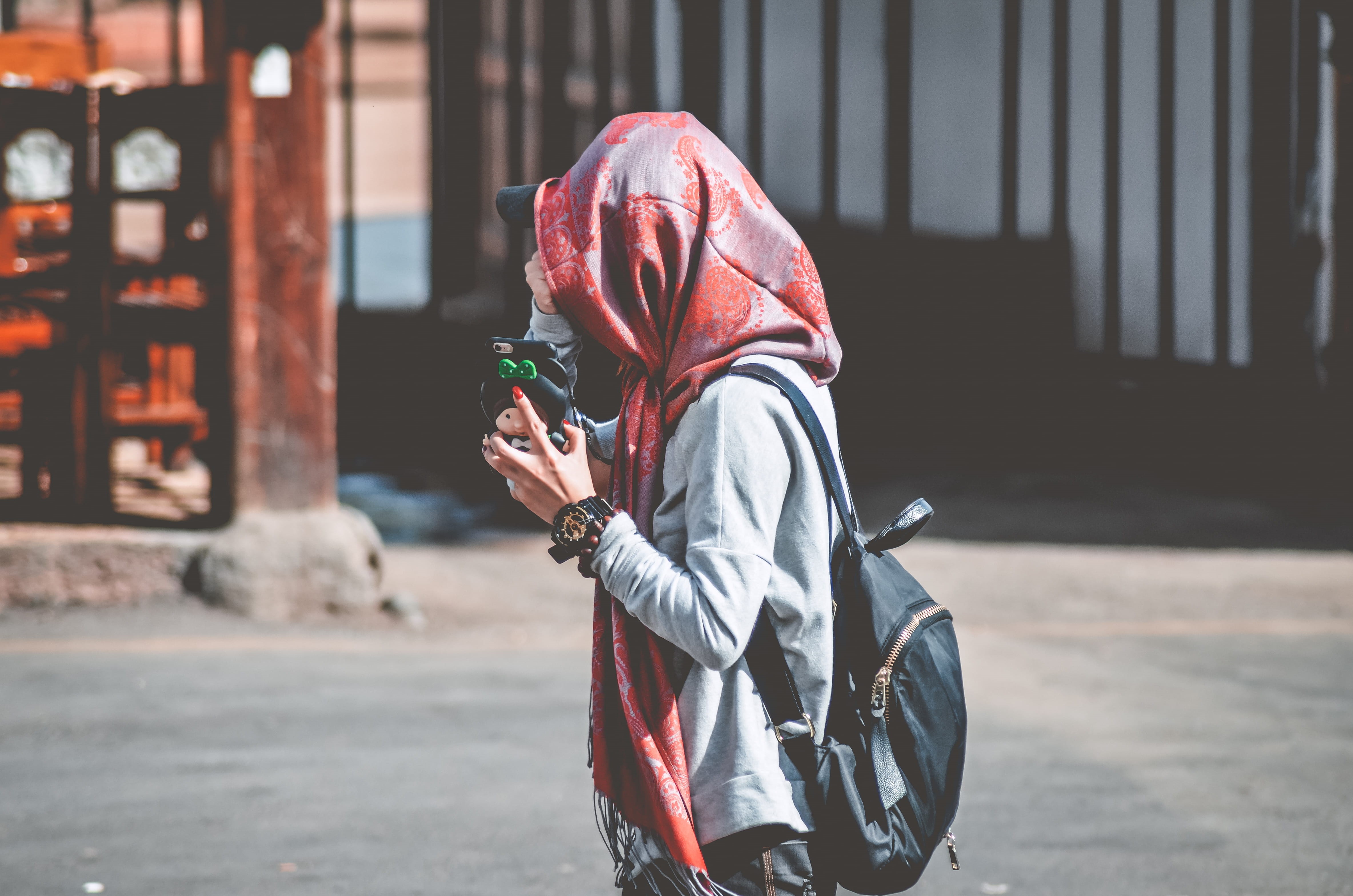 phone, building, photo, daytime, backpack, hood - clothing, holding, lifestyles, three quarter length, near, brown, red, casual clothing, street, hijab, HD Wallpaper