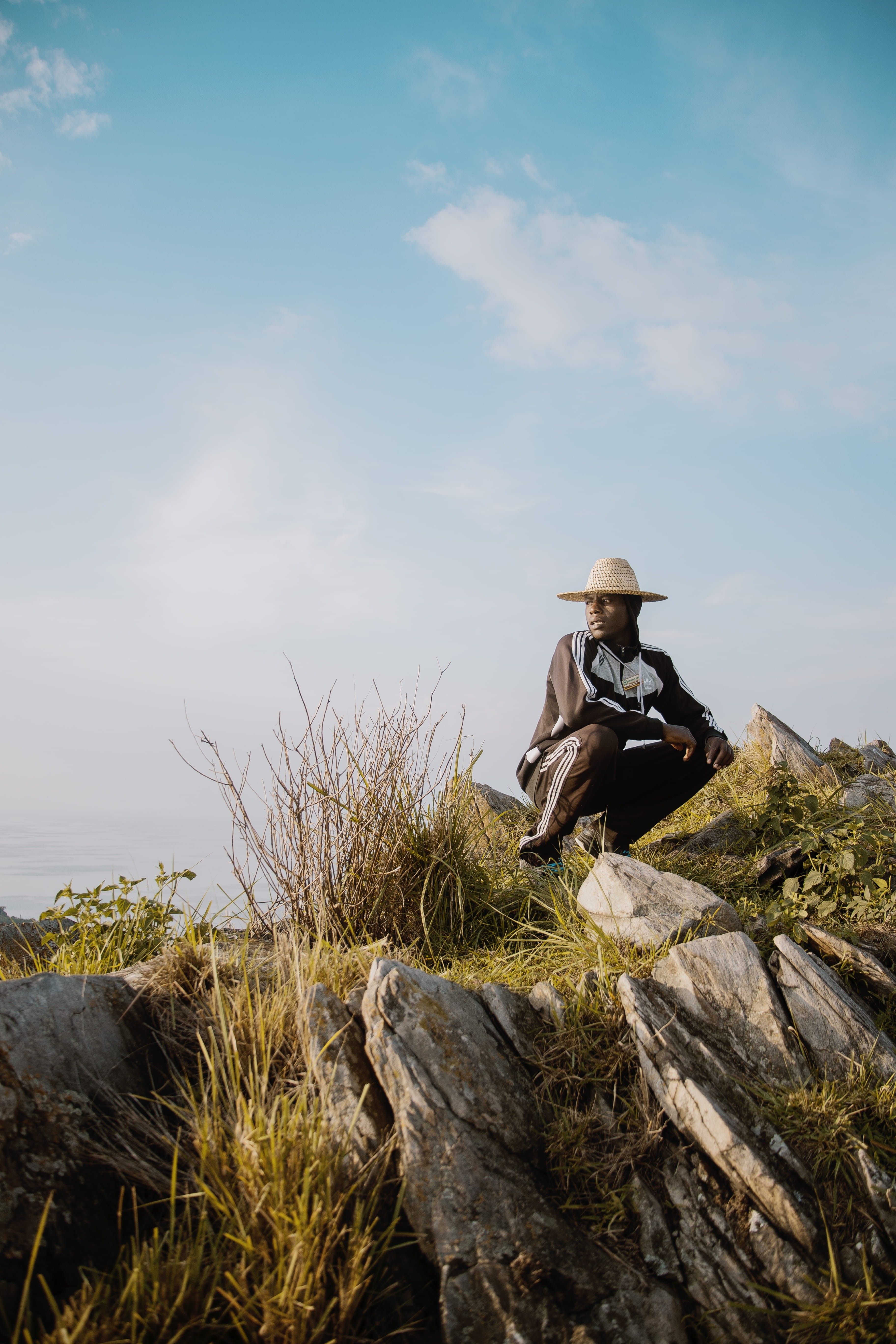 land, full length, rwanda, real people, plant, solid, leisure activity, rock - object, sitting, hike, one person, 5K, lifestyles, cloud - sky, beauty in nature, Phone HD Wallpaper