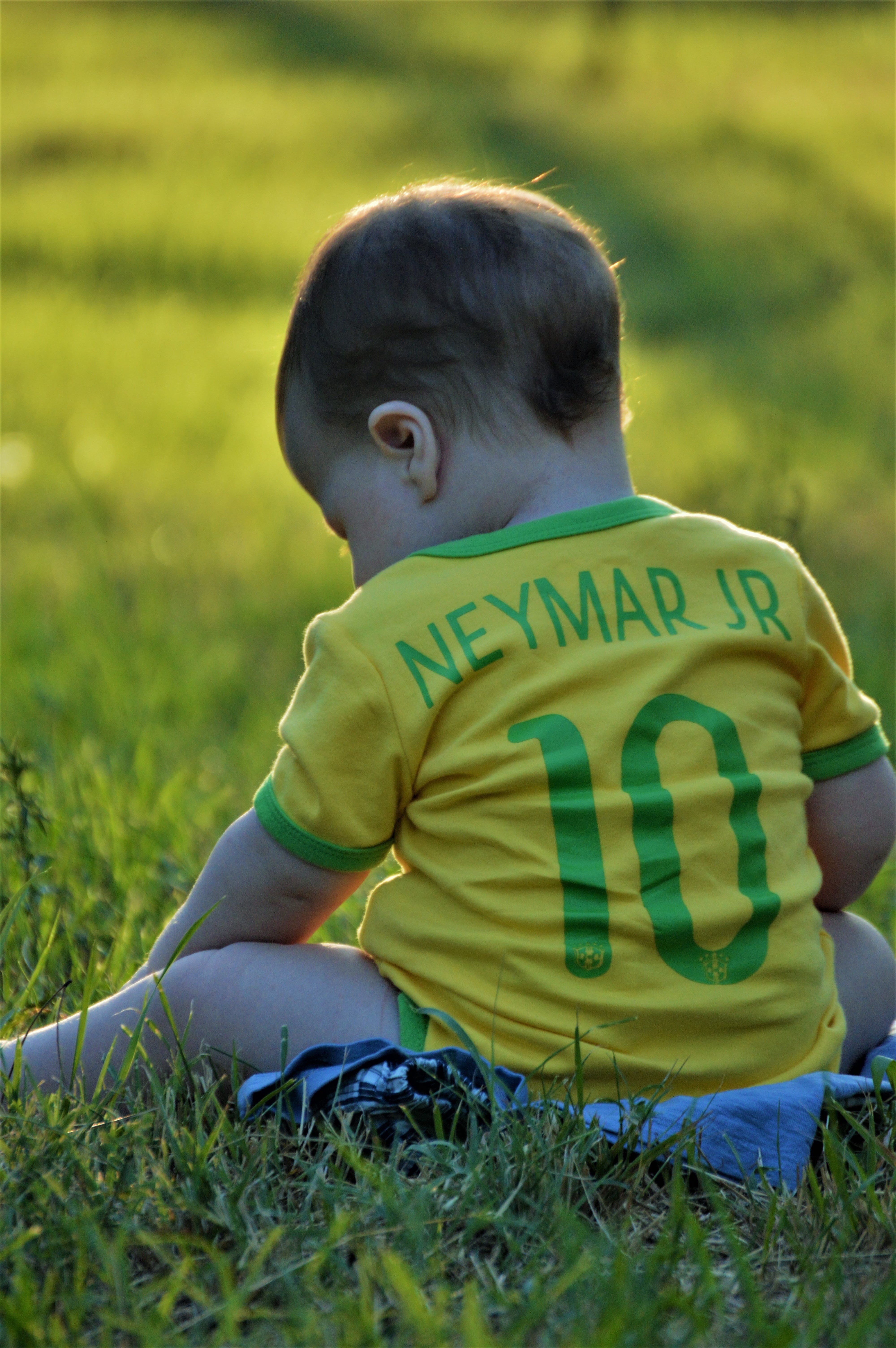 sitting, casual clothing, ipanema, plant, adorable, 5K, men, neymar jr, blond, brazil, fun, hair, leaf, love, baby, leaves, grass, joy, football, child, Phone HD Wallpaper