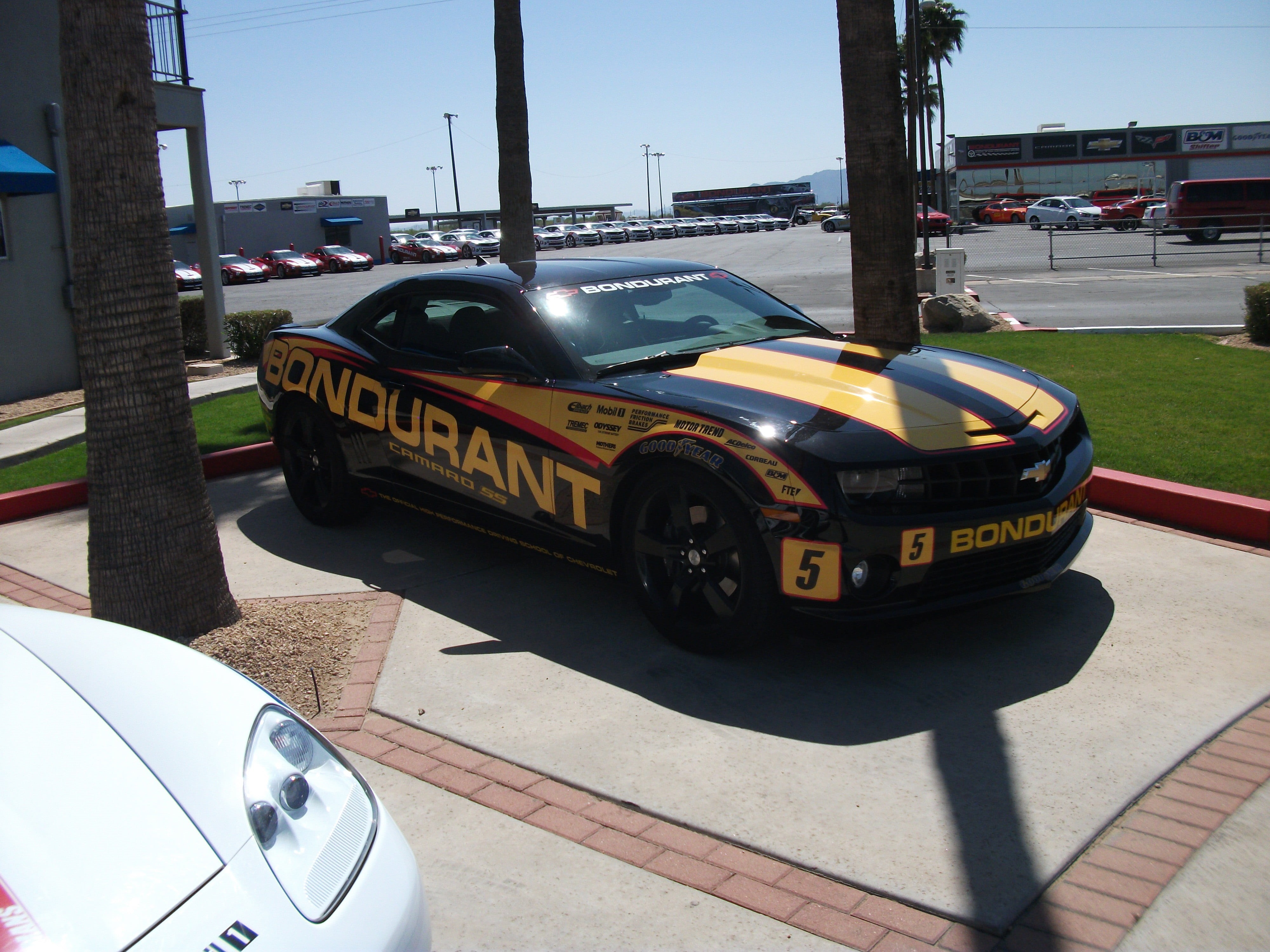 sign, built structure, city, shadow, land vehicle, black, outdoors, sunlight, nature, personal, Chevrolet, Chevrolet Camaro, street, sky, watercraft, bondurant, HD Wallpaper