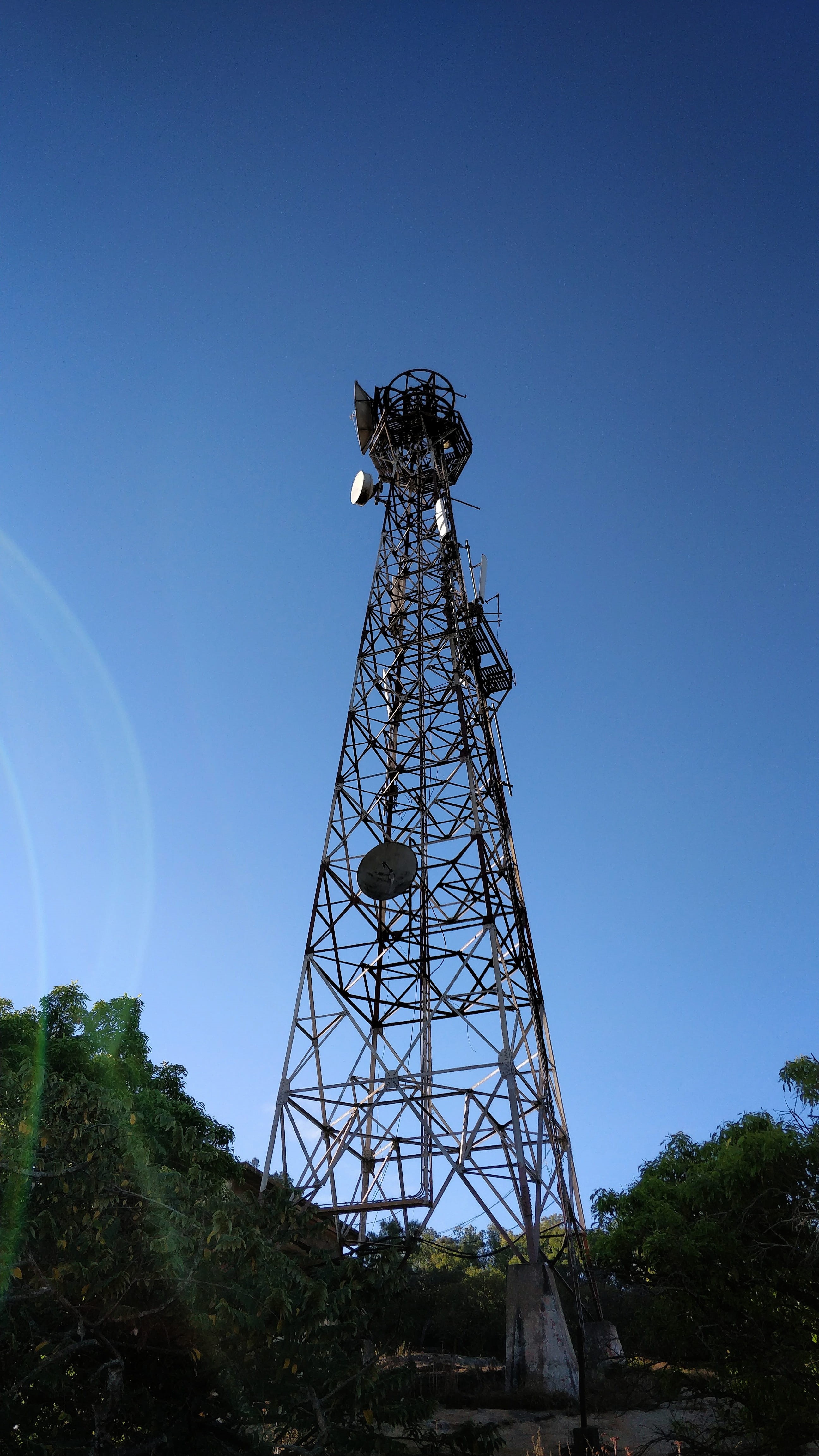 tower, broadcasting, tree, 4K, tall - high, nandi hills, connection, blue, sky, low angle view, architecture, metal, outdoors, antenna, technology, smartphone photography, Phone HD Wallpaper