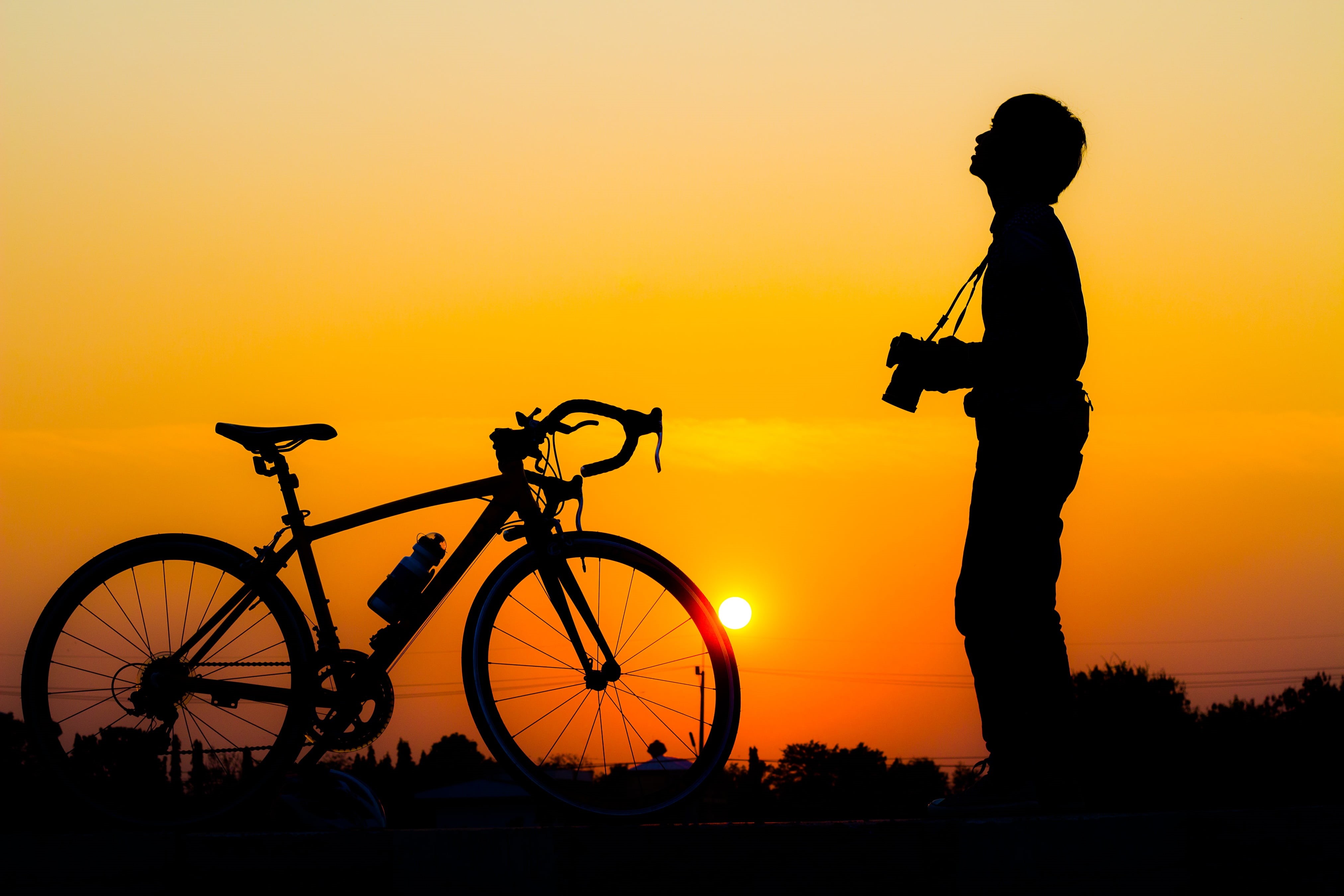 lifestyles, mode of transportation, happy, silhouette, standing, adult, the sun, bike, sky, people, queen s, happiness, life, two, side view, activity, HD Wallpaper