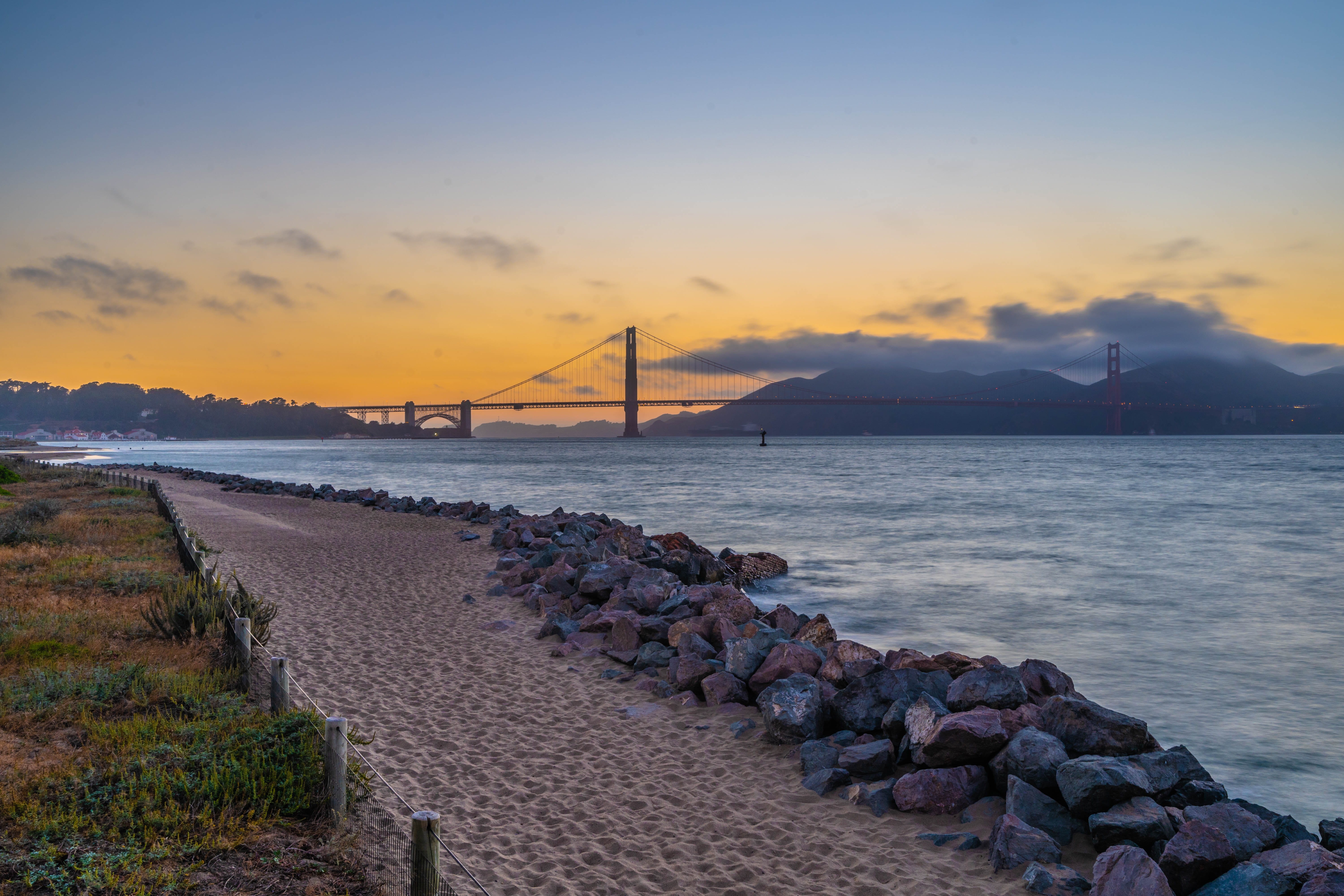 shore, cloud - sky, connection, ocean, sunset, pebble, tranquil scene, sunrise, rock, water, no people, 5K, solid, sand, coast, golden gate bridge, wave, HD Wallpaper
