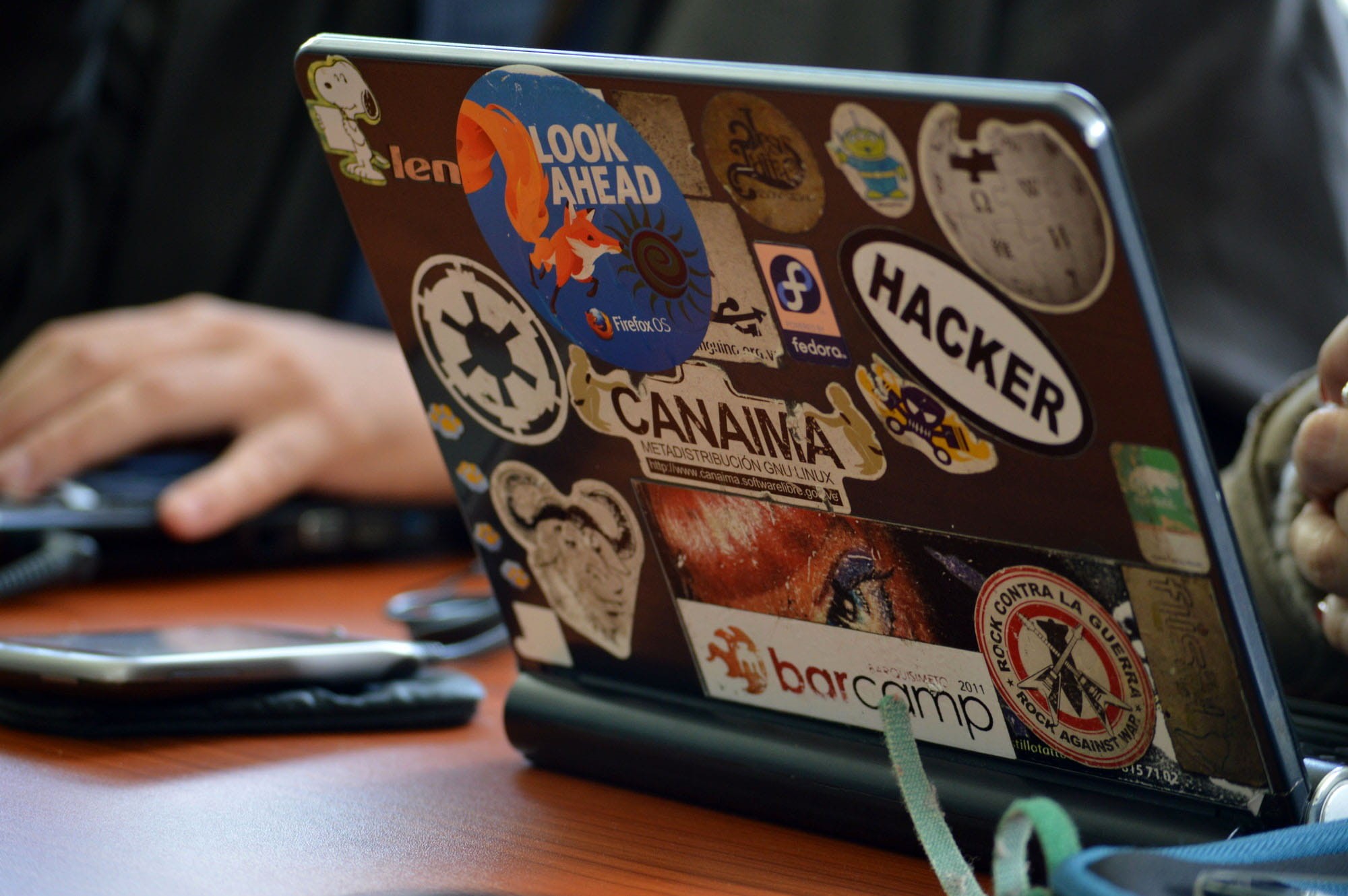 Laptop, table, technology, communication, finger, holding, text, drink, stickers, tech, computers, day, men, hacker, wireless technology, hand, food and drink, HD Wallpaper