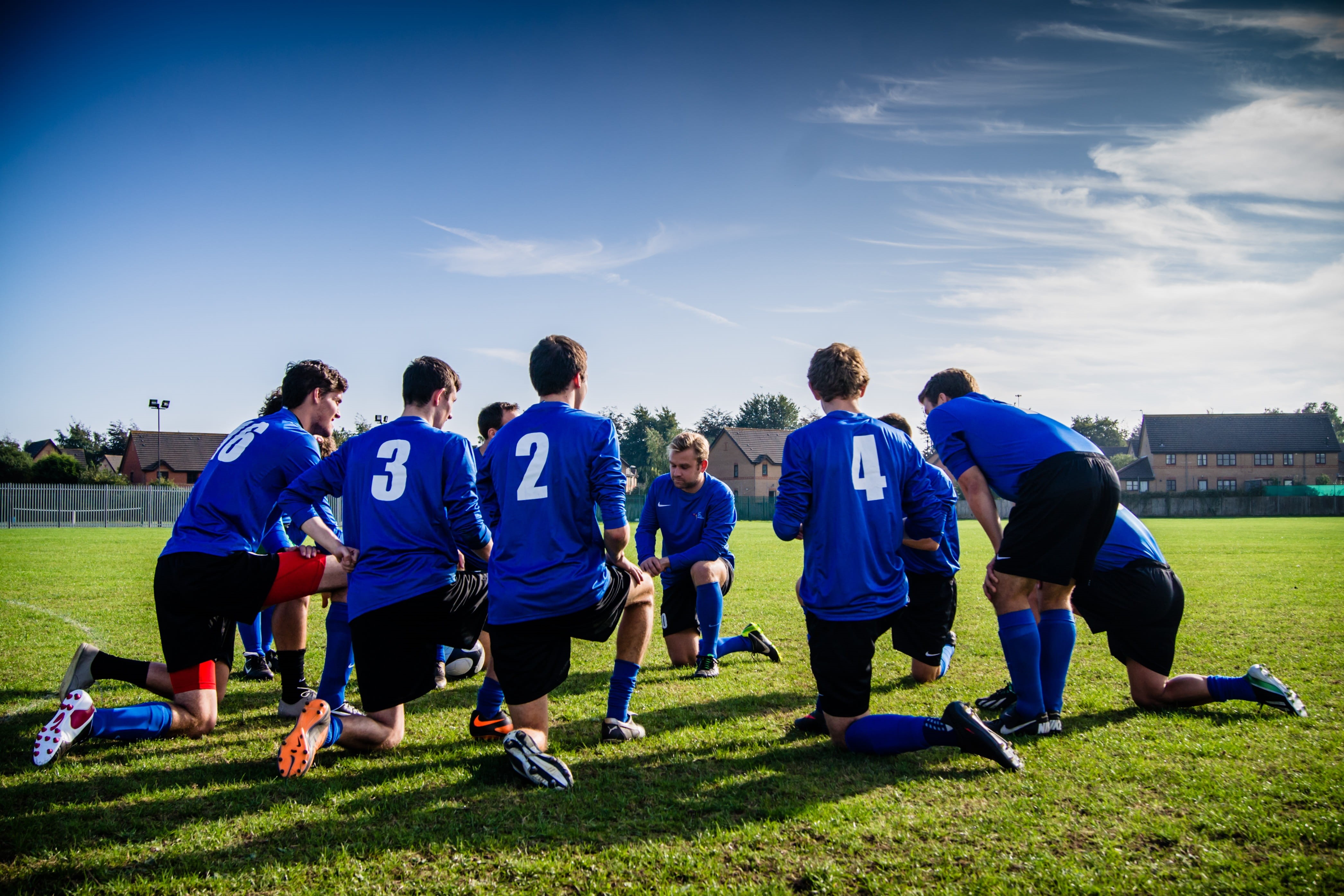 sports uniform, teamwork, kneeling, soccer player, men, sports clothing, fun, cooperation, activity, group, real people, grass, soccer, play, coach, ball, HD Wallpaper