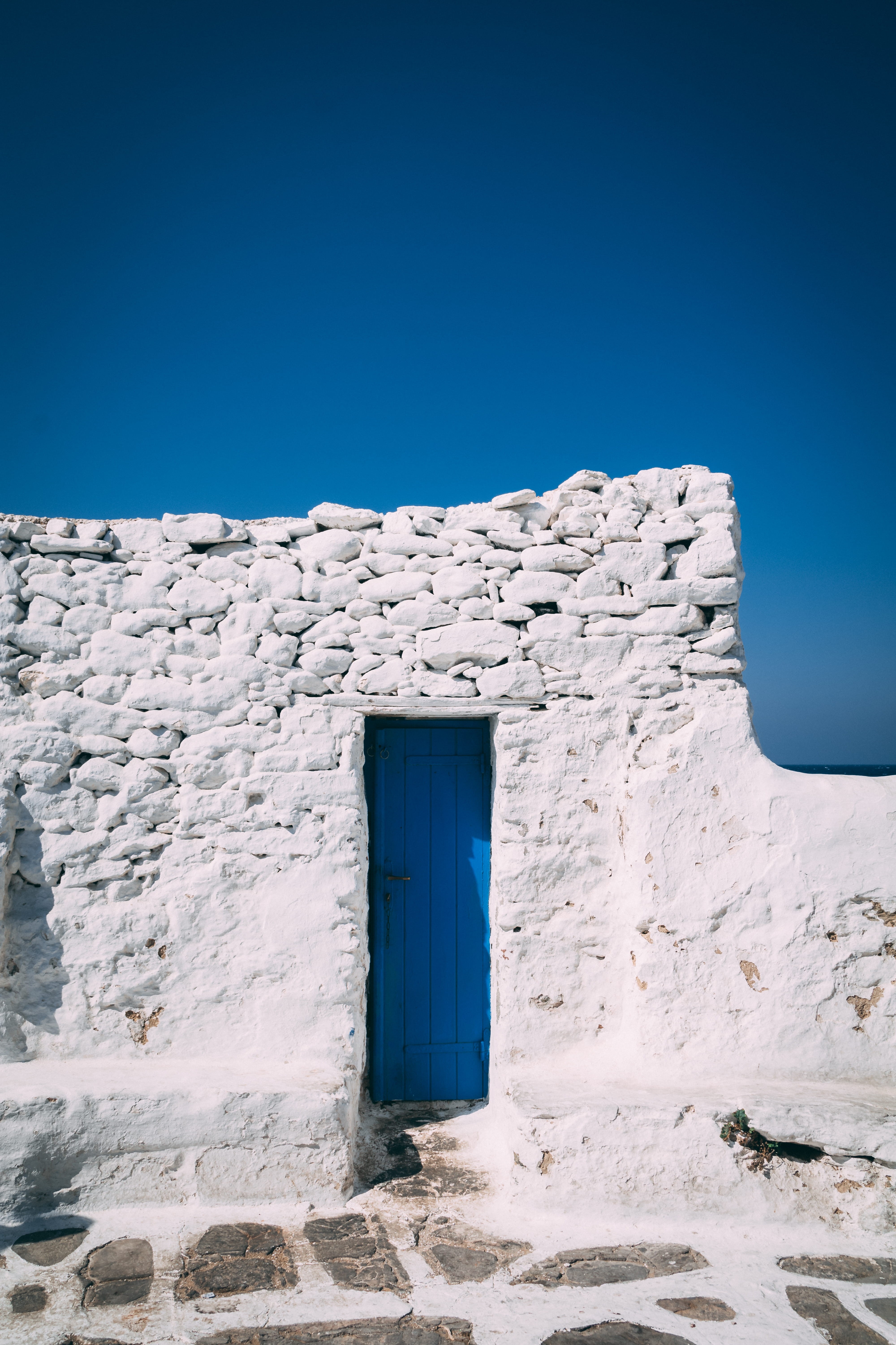 built Structure, blue sky, house, white bricks, blue, blue and white, history, paint, wooden door, tourism, brick, simplicity, outdoors, wall, Phone HD Wallpaper