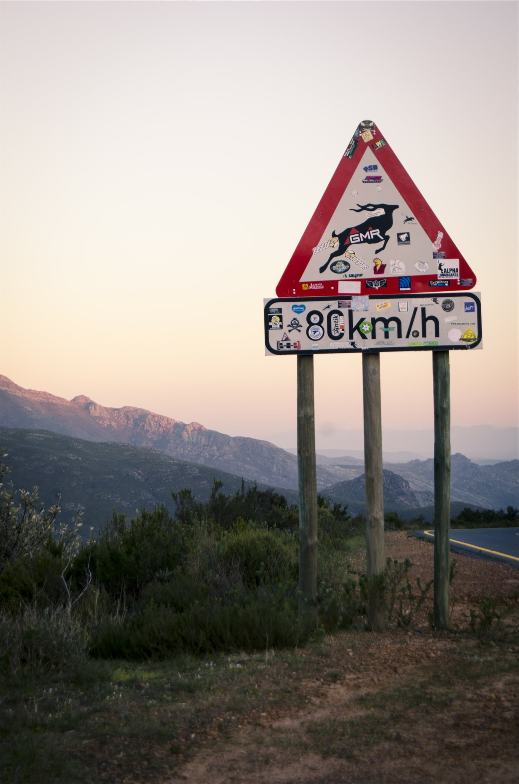 environment, landscape, road sign, beauty in nature, road, outdoors, sunset, nature, full, speed limit, communication, signage, grass, near, mountains, Phone HD Wallpaper