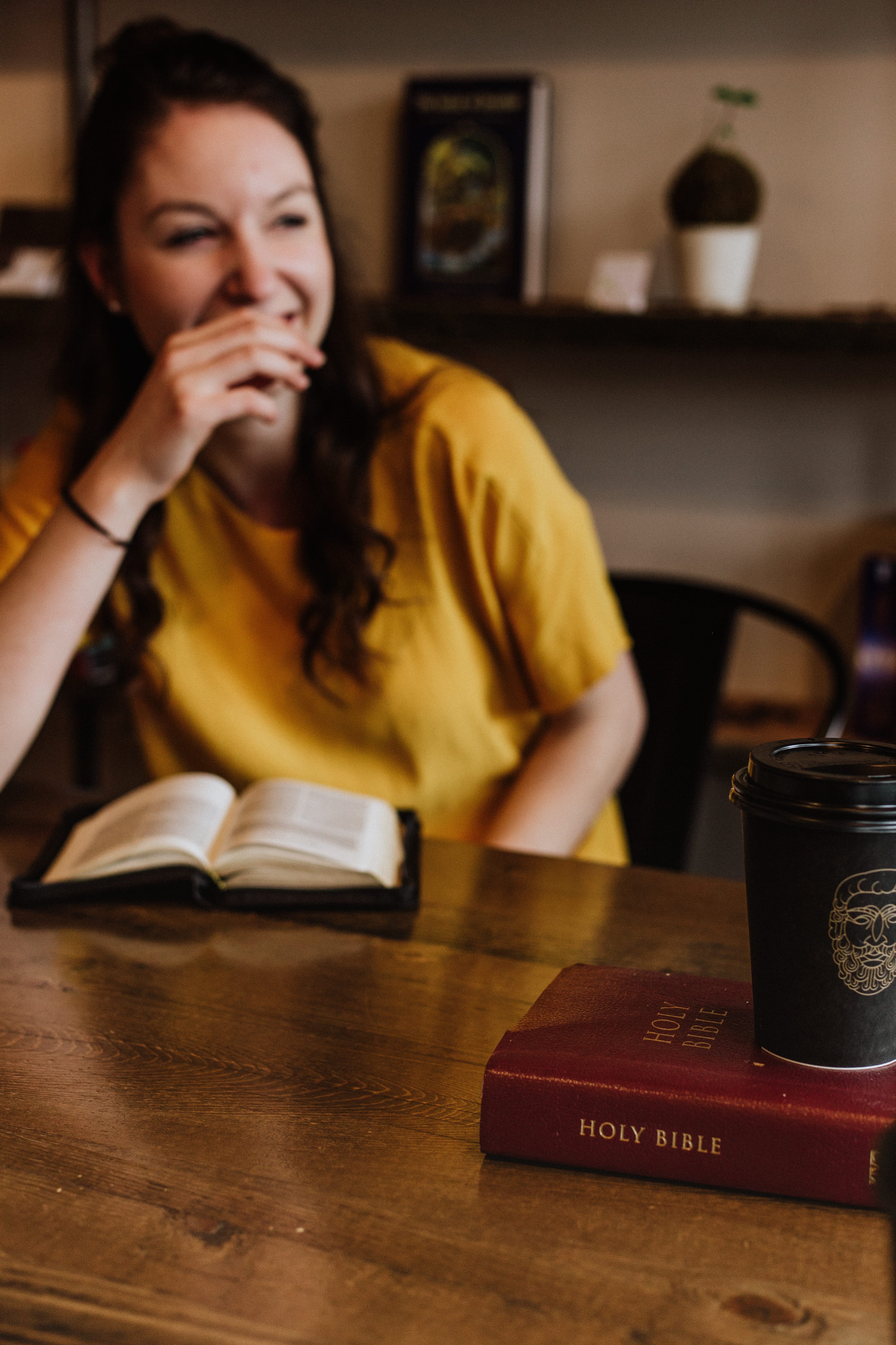 holy, waist up, front view, talking, near, drink, headshot, sitting, woman, siting, activity, book, front, focus on foreground, talk, lifestyles, bible, Phone HD Wallpaper