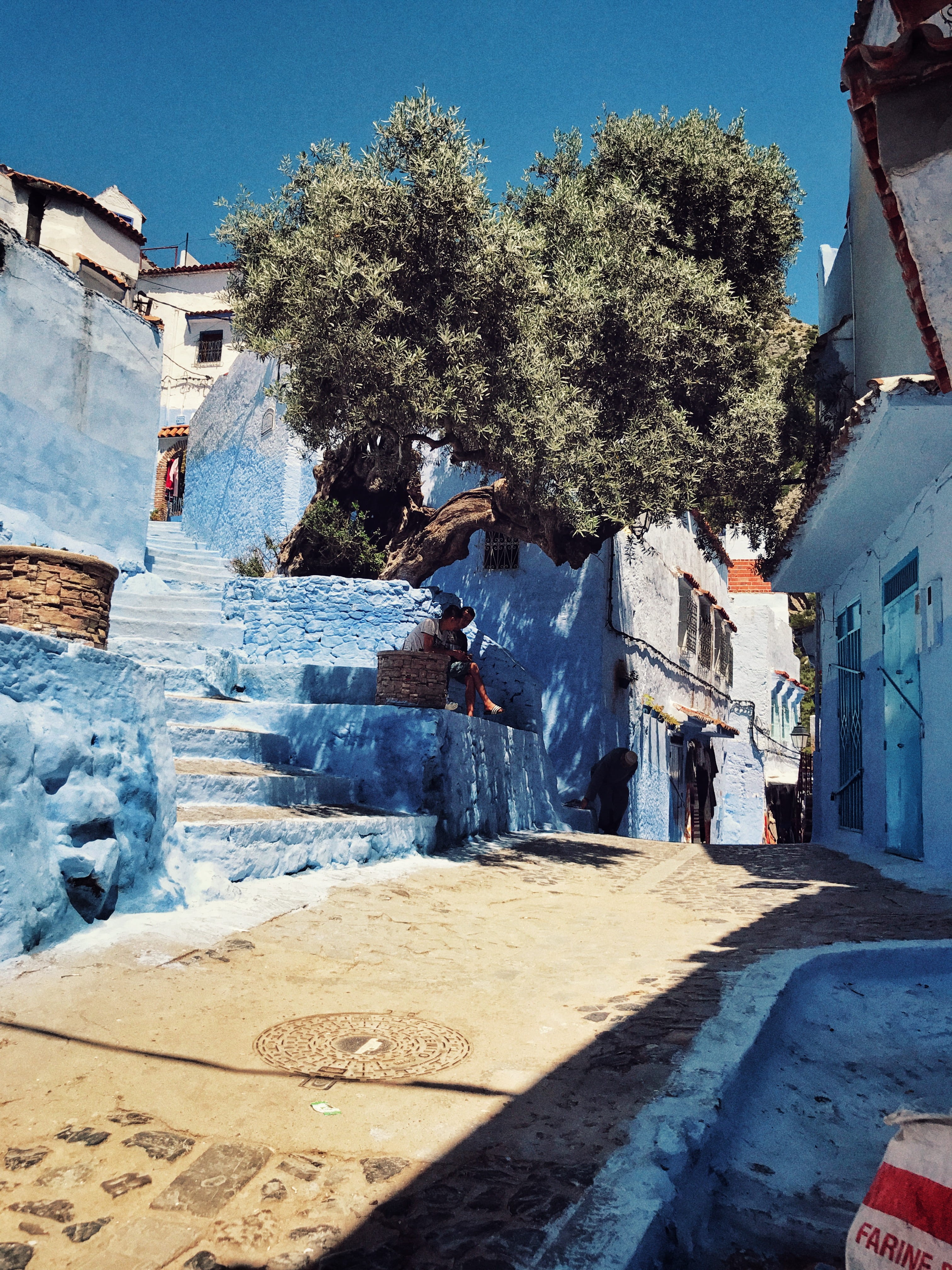 building, clear sky, incidental people, motor vehicle, city, morocco, blue, scenery, architecture, people, day, sunlight, chefchaouen, sky, outdoors, pavement, Phone HD Wallpaper