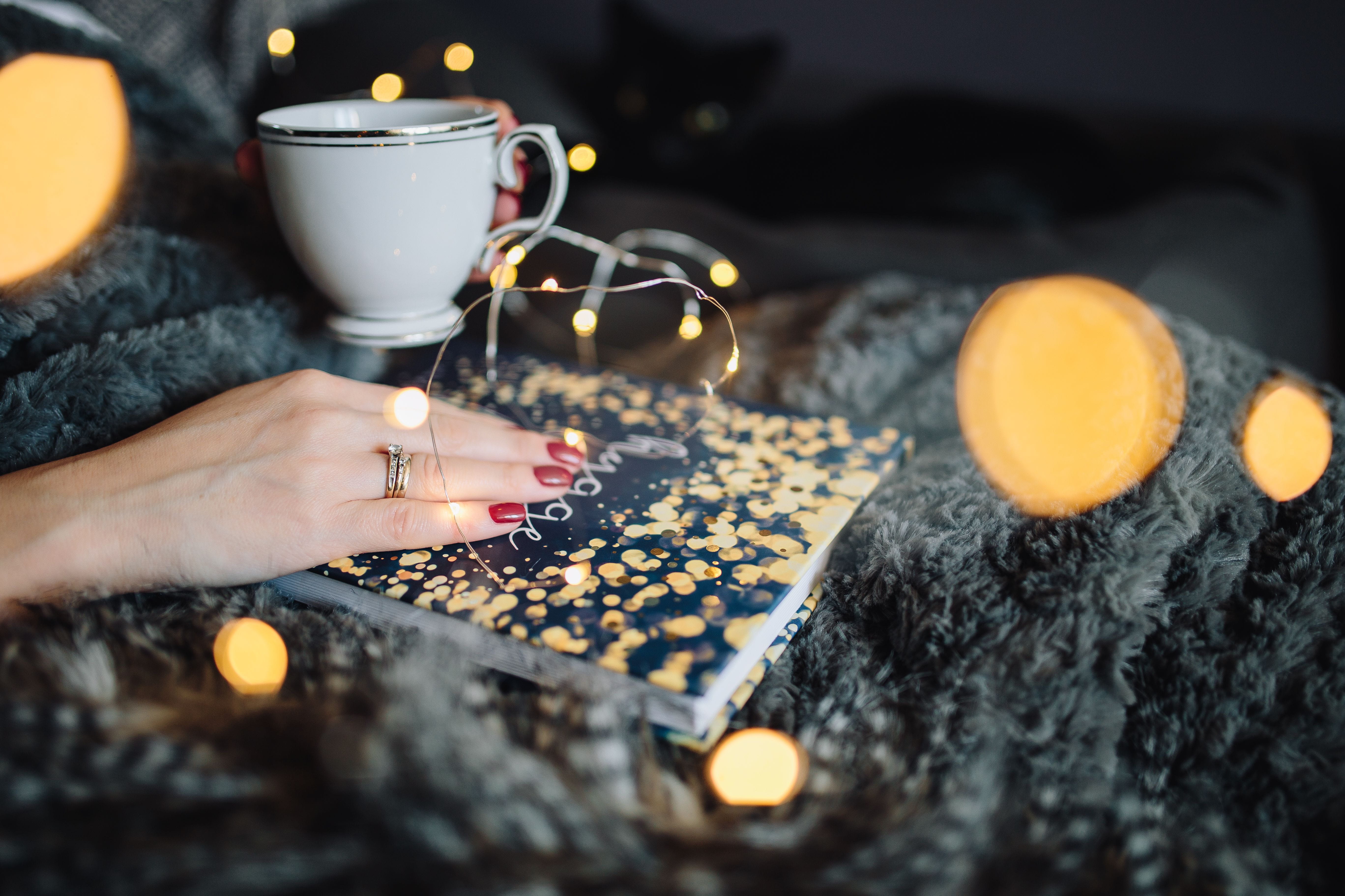 indoors, cup, drinking, human limb, young, femine, drink, burning, reading, tea light, fairy lights, illuminated, book, christmas, Hygge, adult, cookie, HD Wallpaper