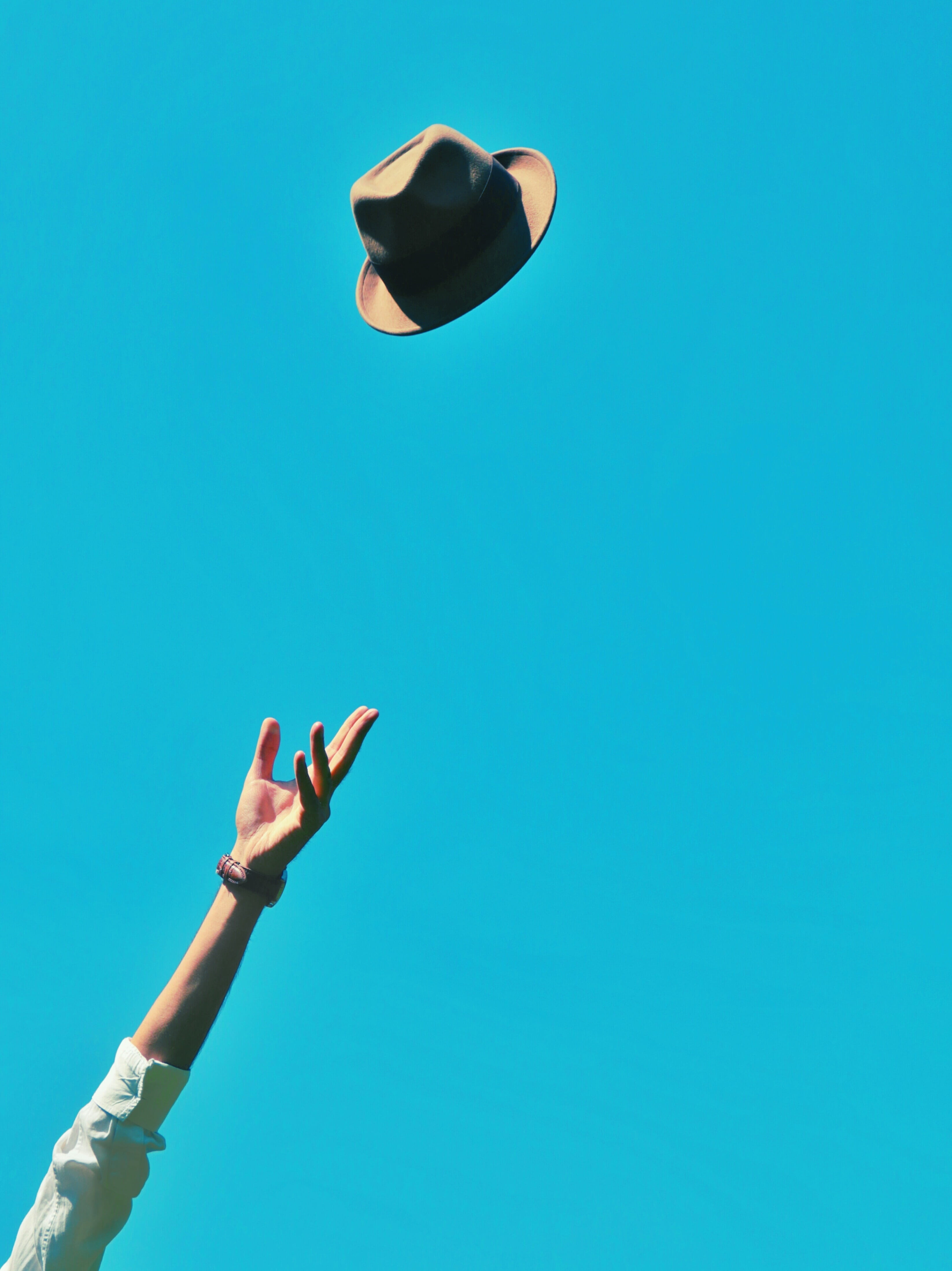 person, blue, day, bracelet, real people, sky, outdoors, throwing, human body part, fedora, mid-air, air, leisure activity, adults only, copy space, one person, Phone HD Wallpaper