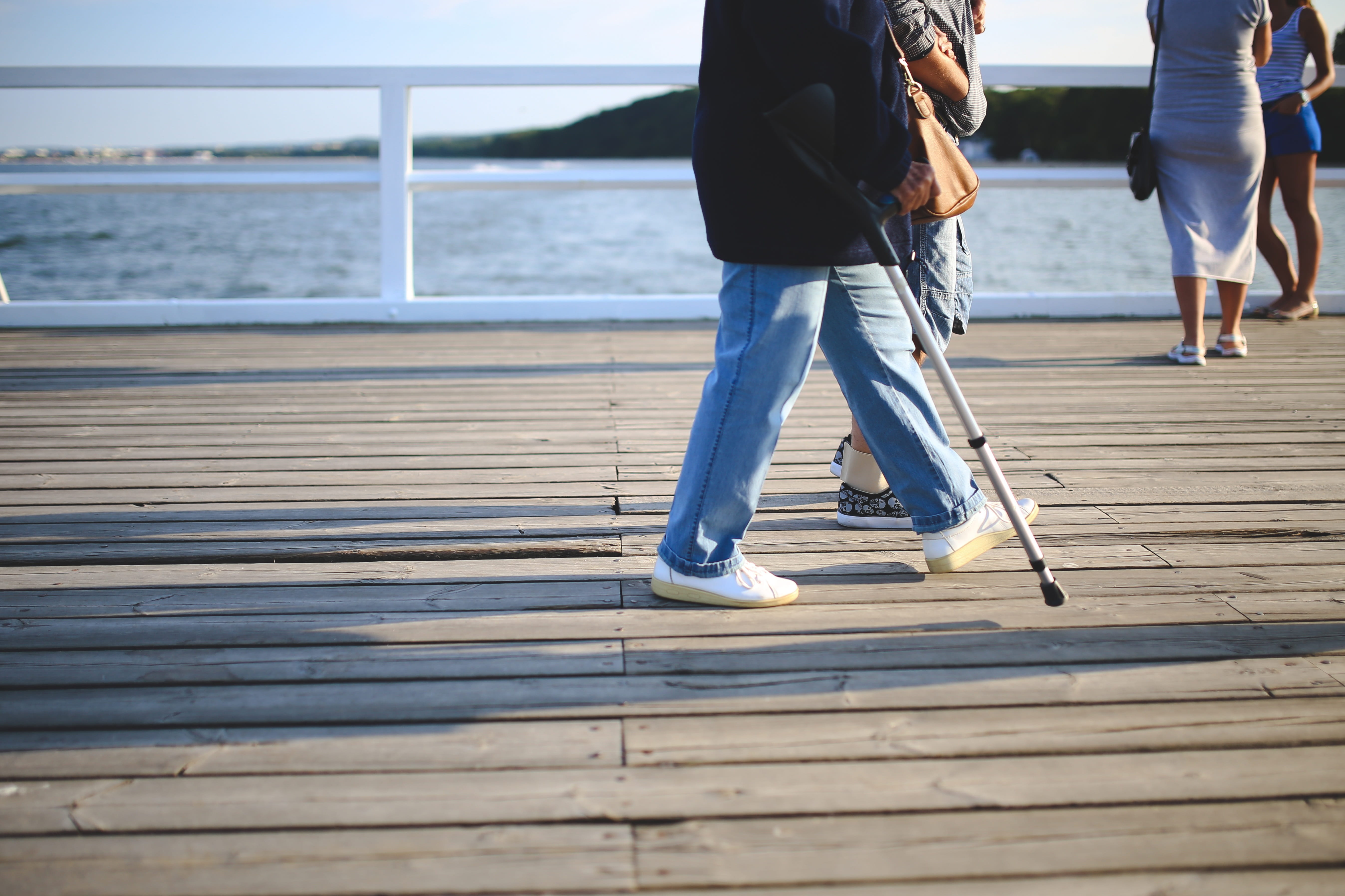 walking on, lifestyles, two people, sea, sunlight, day, casual clothing, leisure activity, adult, jeans, crutch, old, low section, outdoors, man, water, HD Wallpaper