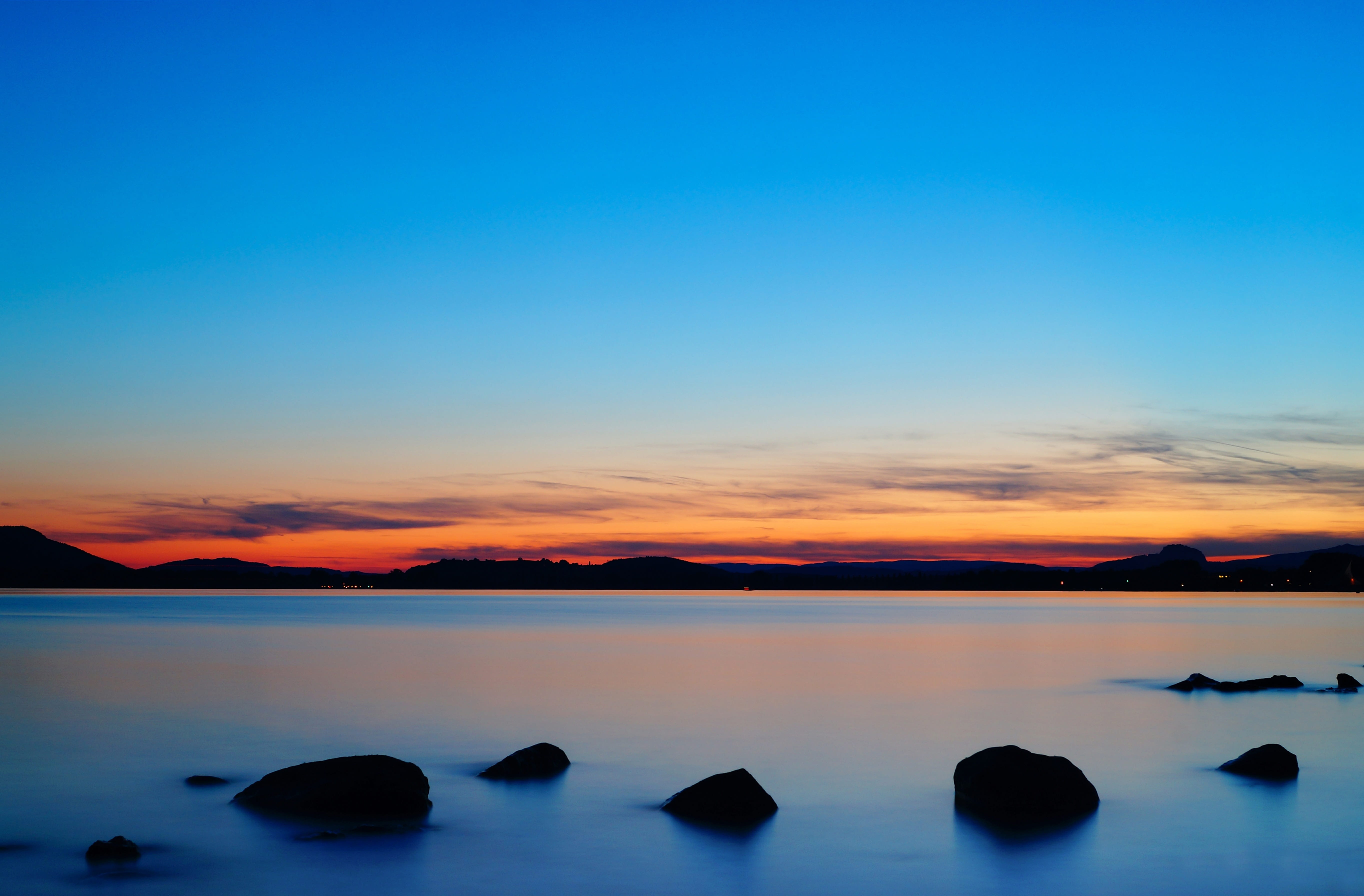 sunset, clouds, 5K, tranquility, blue, copy space, cloud - sky, stones, idyllic, lake constance, orange color, lake, water, tranquil scene, beauty in nature, HD Wallpaper