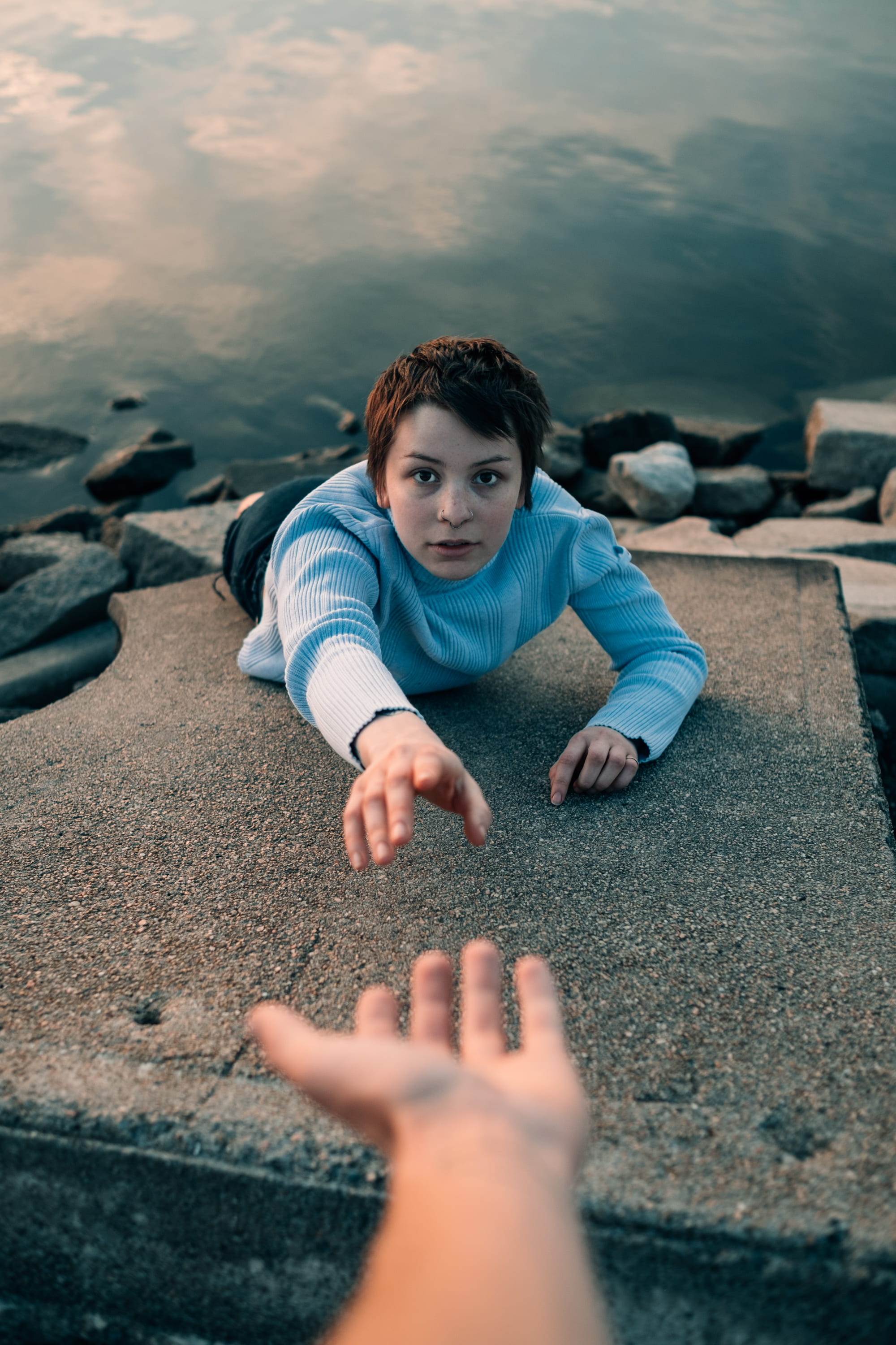 adventure, face, cliff, 2K, lake, lying down, front view, turtleneck, real people, land, people, rock, young adult, assist, falling, photo, outdoors, hand, Phone HD Wallpaper