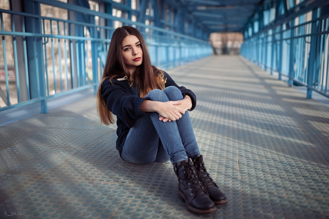 adult, beautiful woman, beautiful people, brown hair, women, long hair, young women, one person, emotion, hairstyle, sitting, women brunette brown eyes jeans sweater holding knees women outdoors red lipstick bridge looking away depth of field, HD Wallpaper