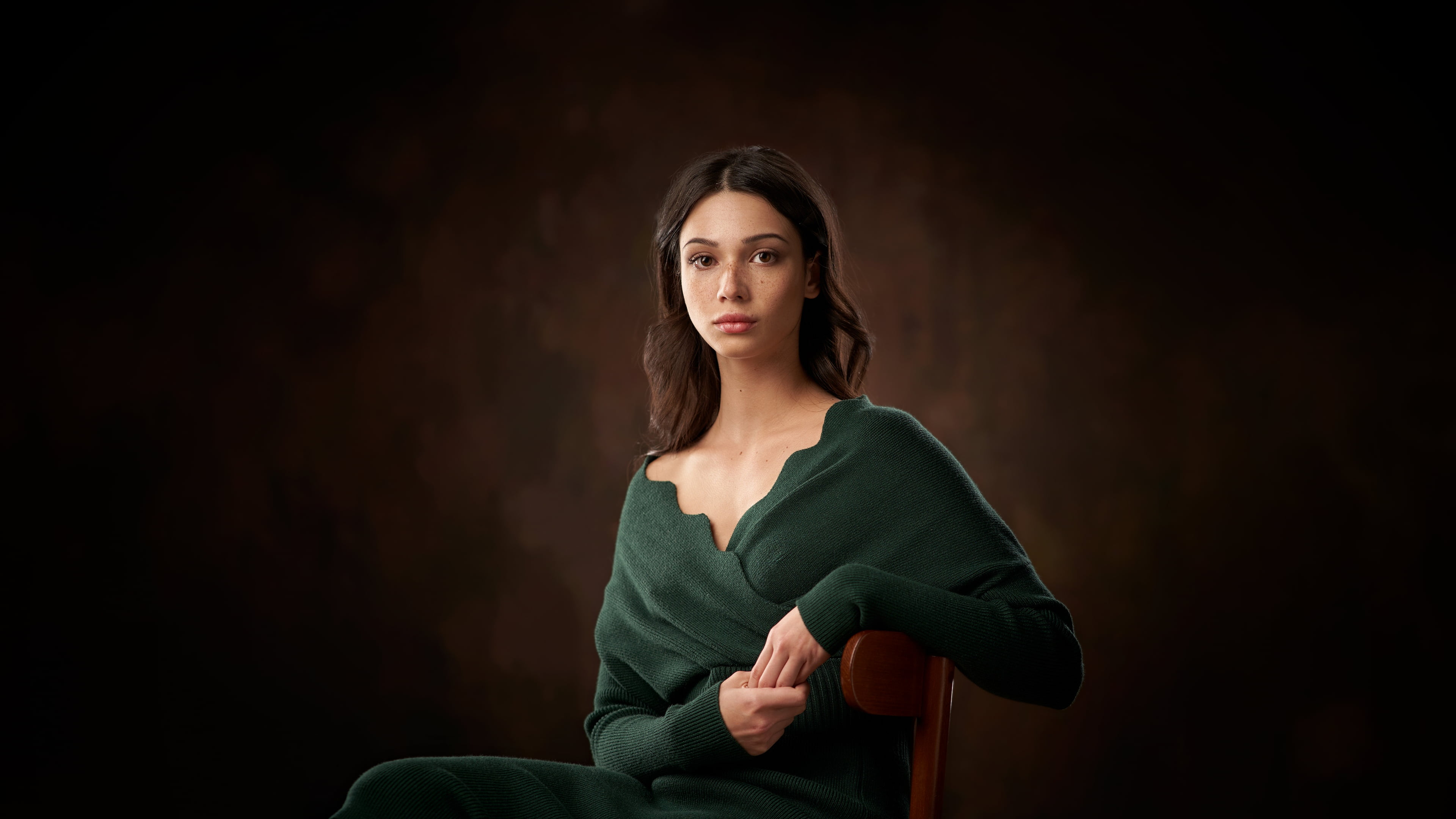women, dark background, depth of field, brunette, sitting, dress, looking at viewer, freckles, Mariya Volokh, brown eyes, chair, dark, 4K, portrait, brown background, HD Wallpaper