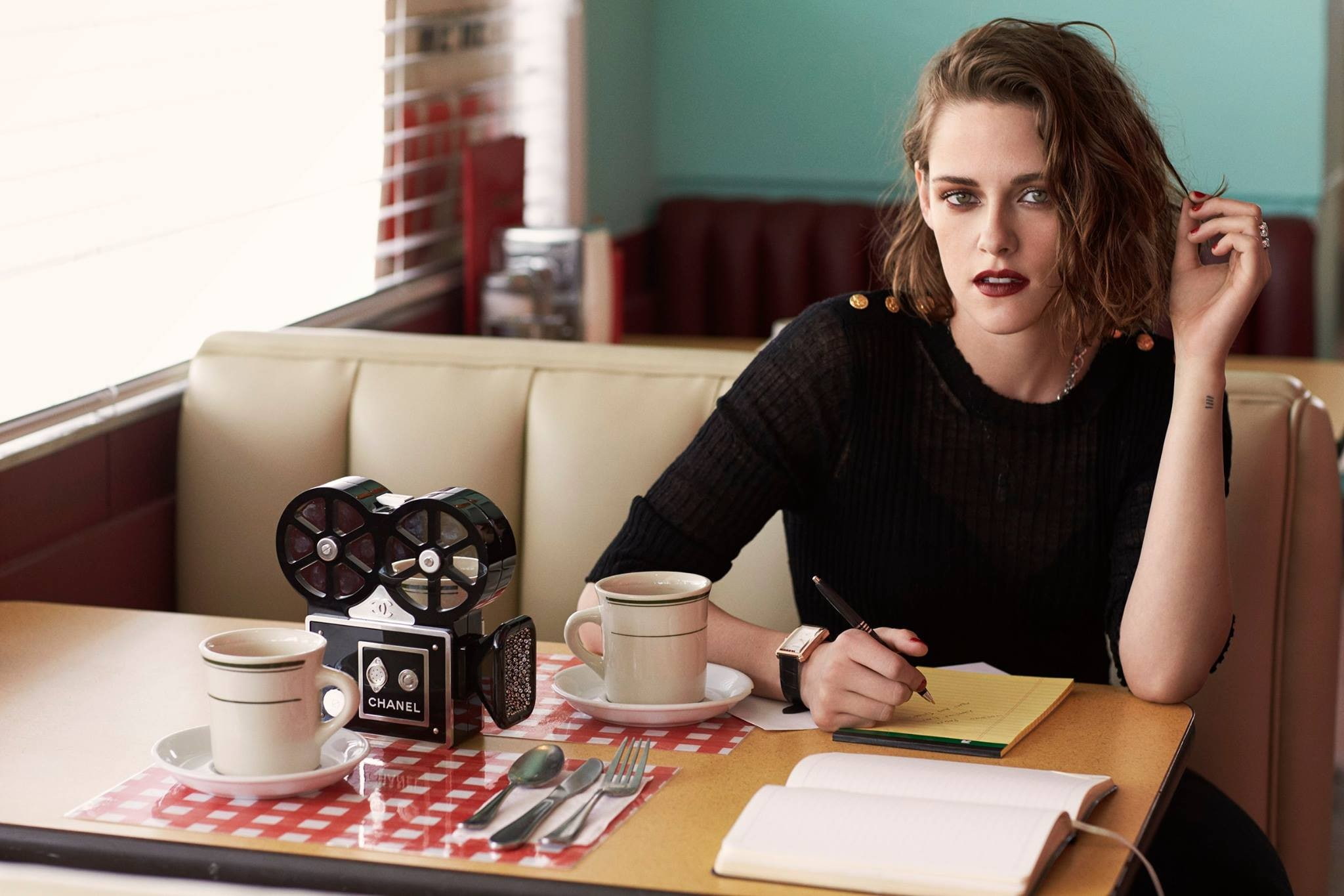 sitting, looking at viewer, cup, celebrity, long hair, Kristen Stewart, camera, table, brunette, cafeteria, books, watch, black dress, actress, pens, writing, HD Wallpaper