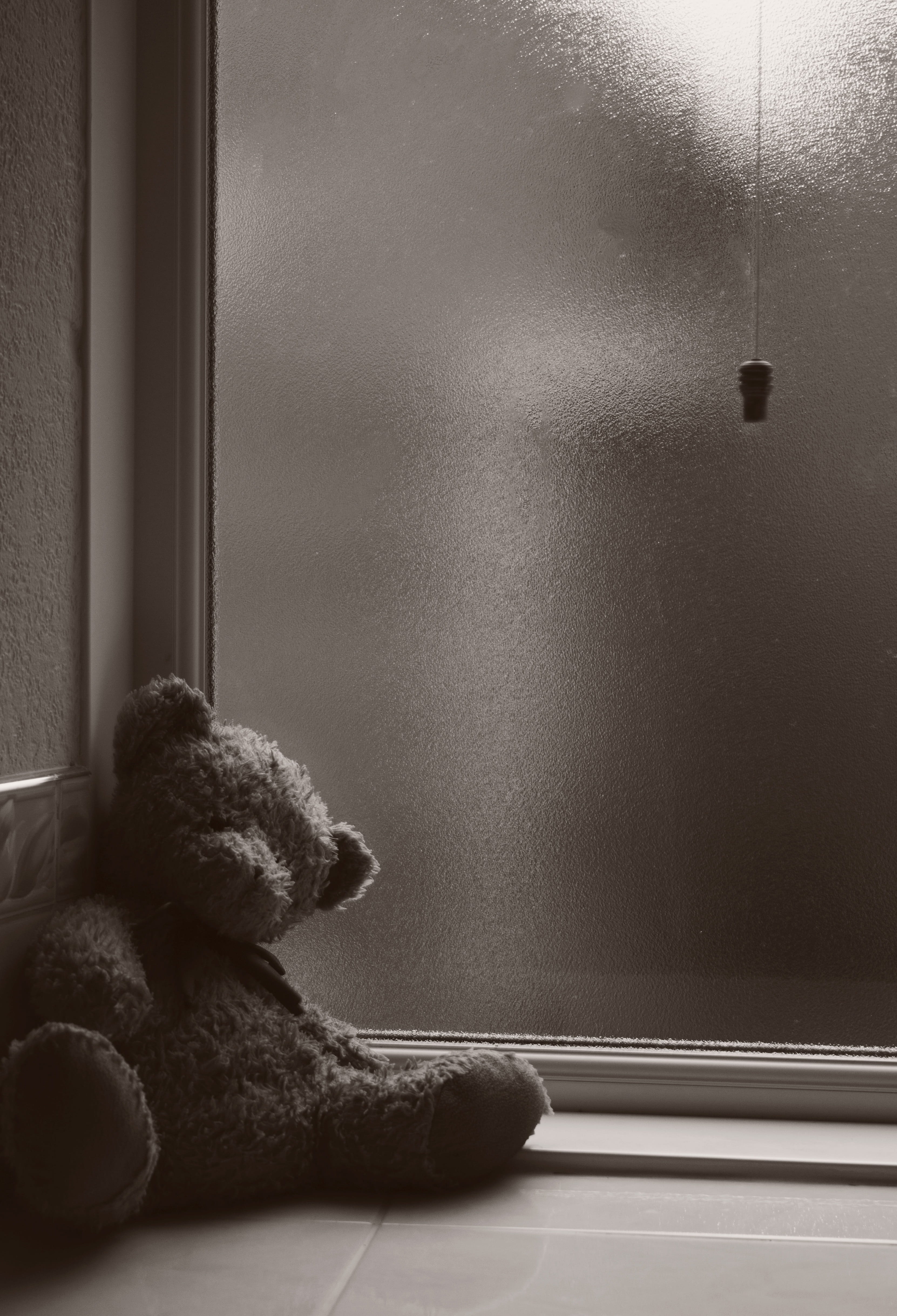 animal representation, Toy, still life, sad, loneliness, lean, wall, childhood, window, 4K, near, domestic room, brown, teddy bear, sadness, glass - material, Phone HD Wallpaper