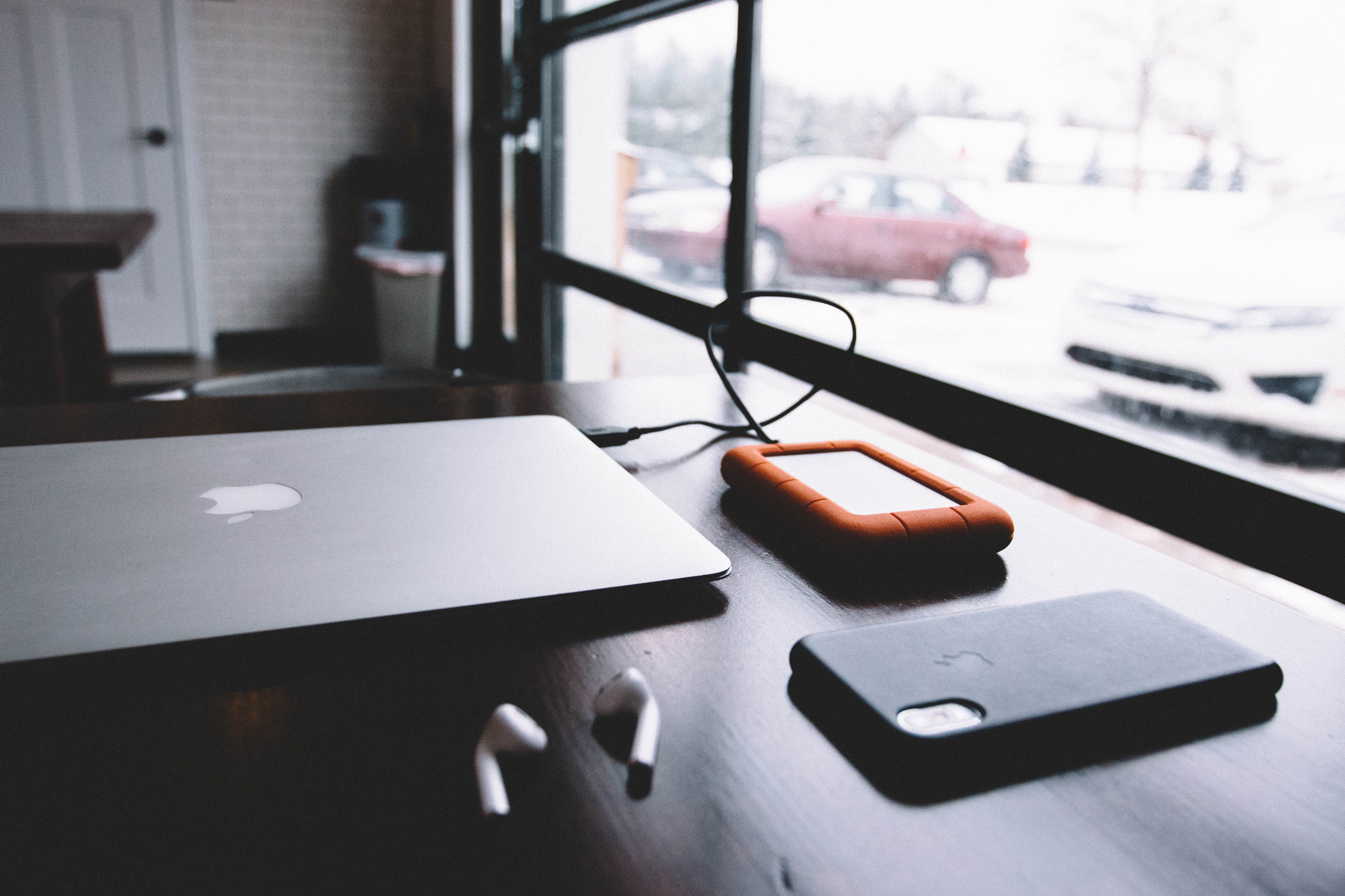mobile phone, brown, plugged, close-up, desk, hard, glasses, selective focus, near, still life, wooden, x, window, airpods, tray, laptop, surface, phone, HD Wallpaper