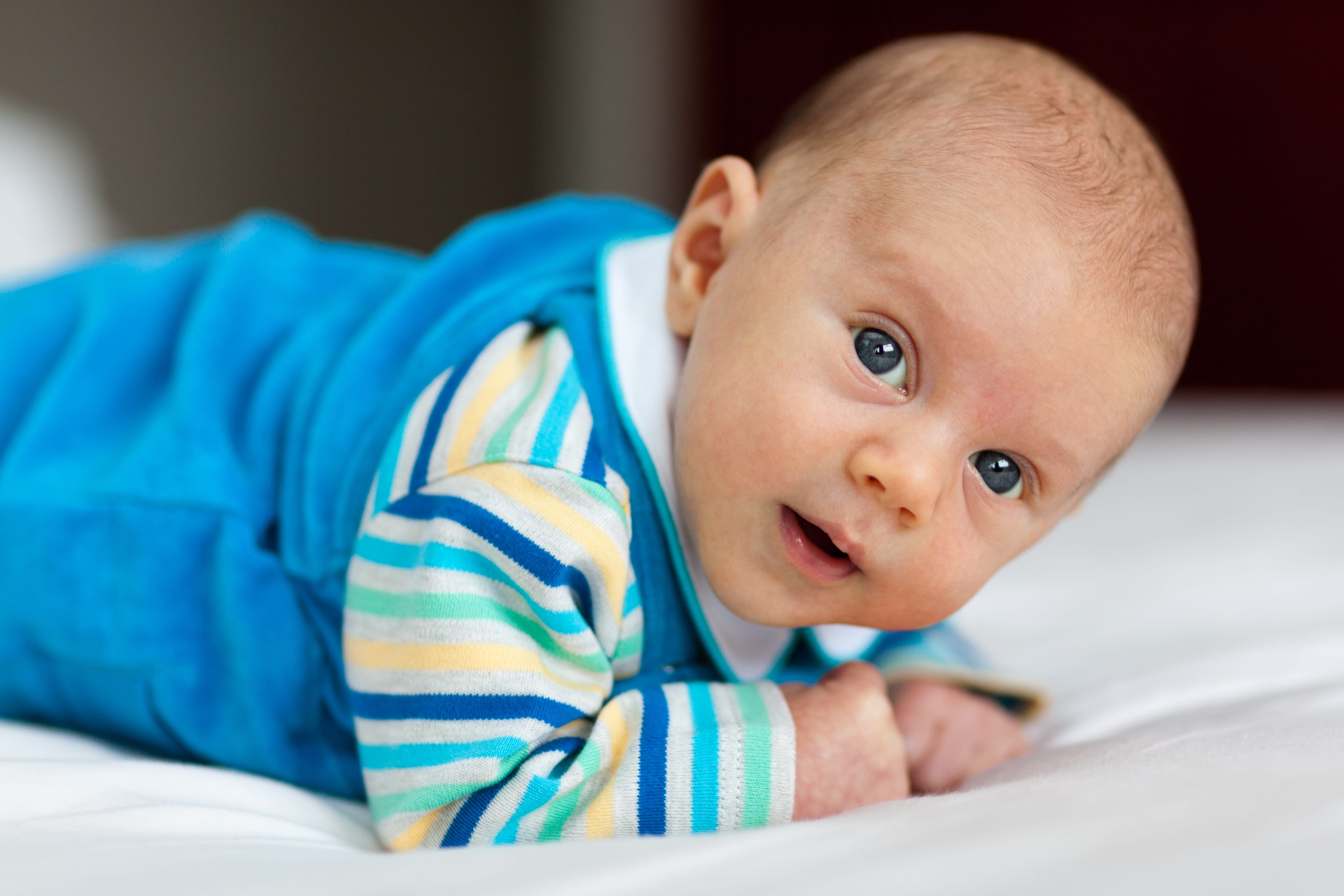 wearing, one person, young, person, baby, footie, blue, look, relaxation, arms, indoors, offspring, bedroom, innocence, looking at camera, lying, belly, HD Wallpaper