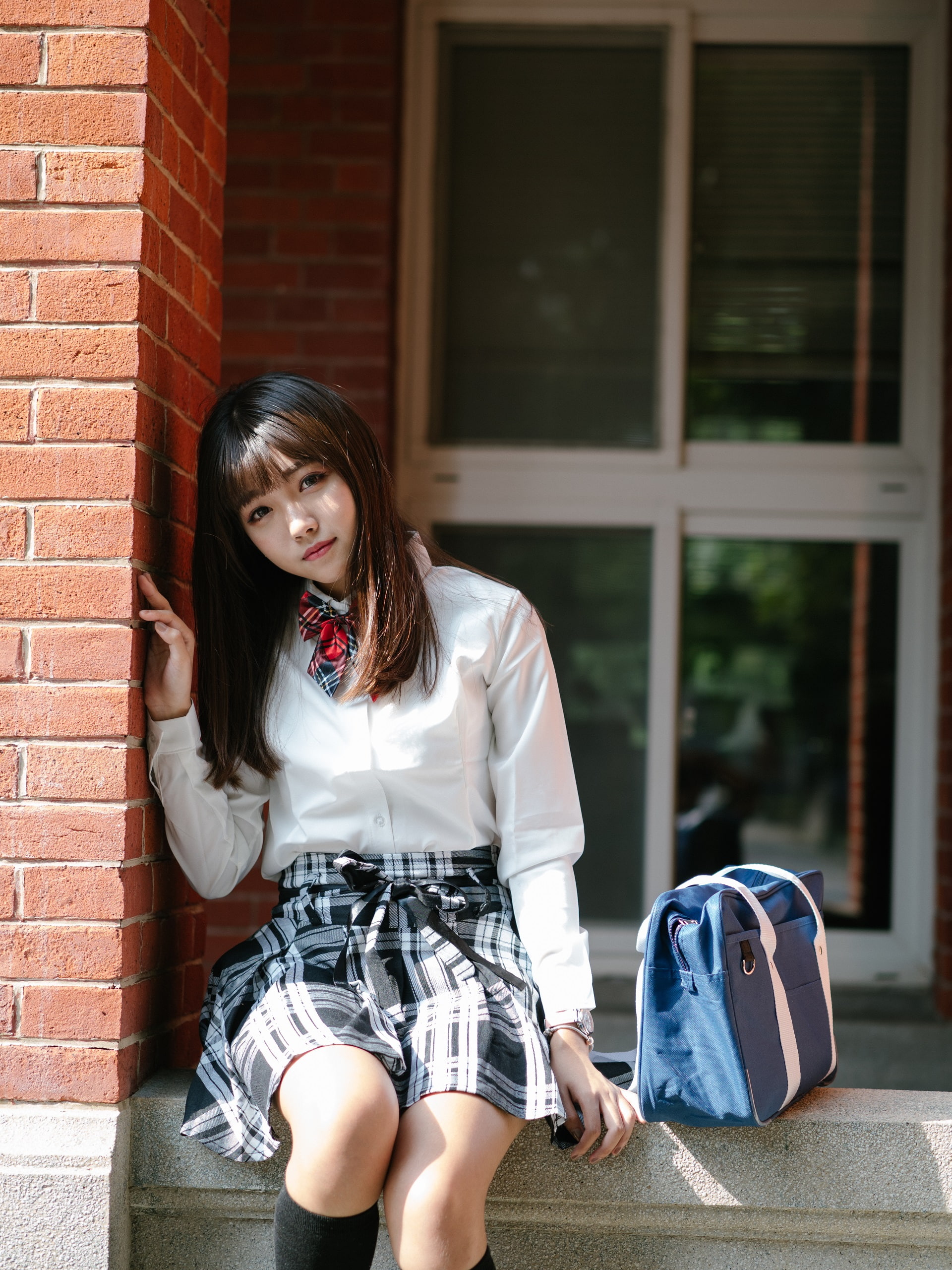 bricks, casual clothing, portrait, outdoors, architecture, skirt, brick wall, sitting, long hair, brunette, young adult, brown hair, shirt, building exterior, Phone HD Wallpaper