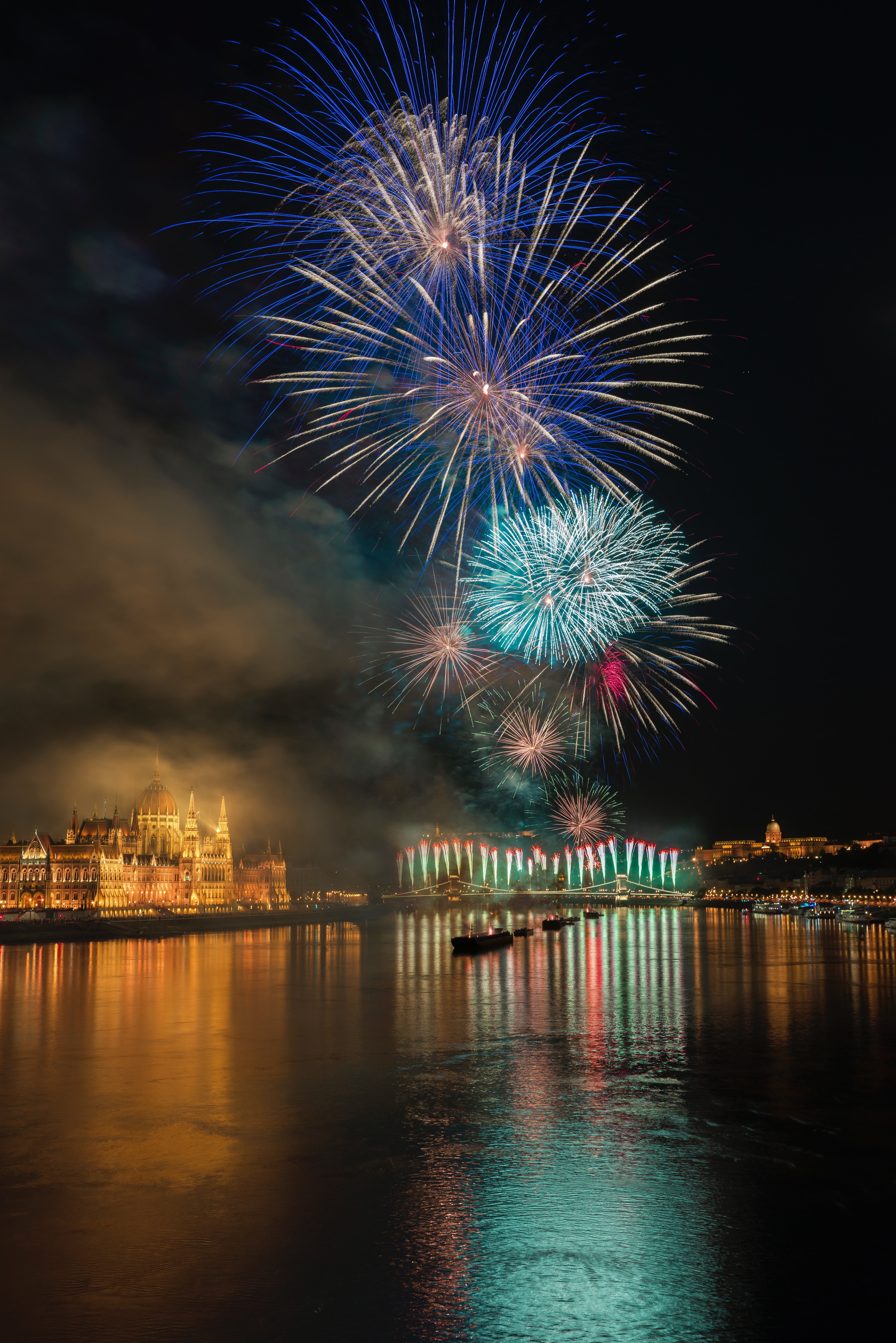 nightlife, new years eve, water, exploding, night city, light, multi colored, firework, 5K, cityscape, celebration, salute, motion, outdoors, firework - man made object, Phone HD Wallpaper
