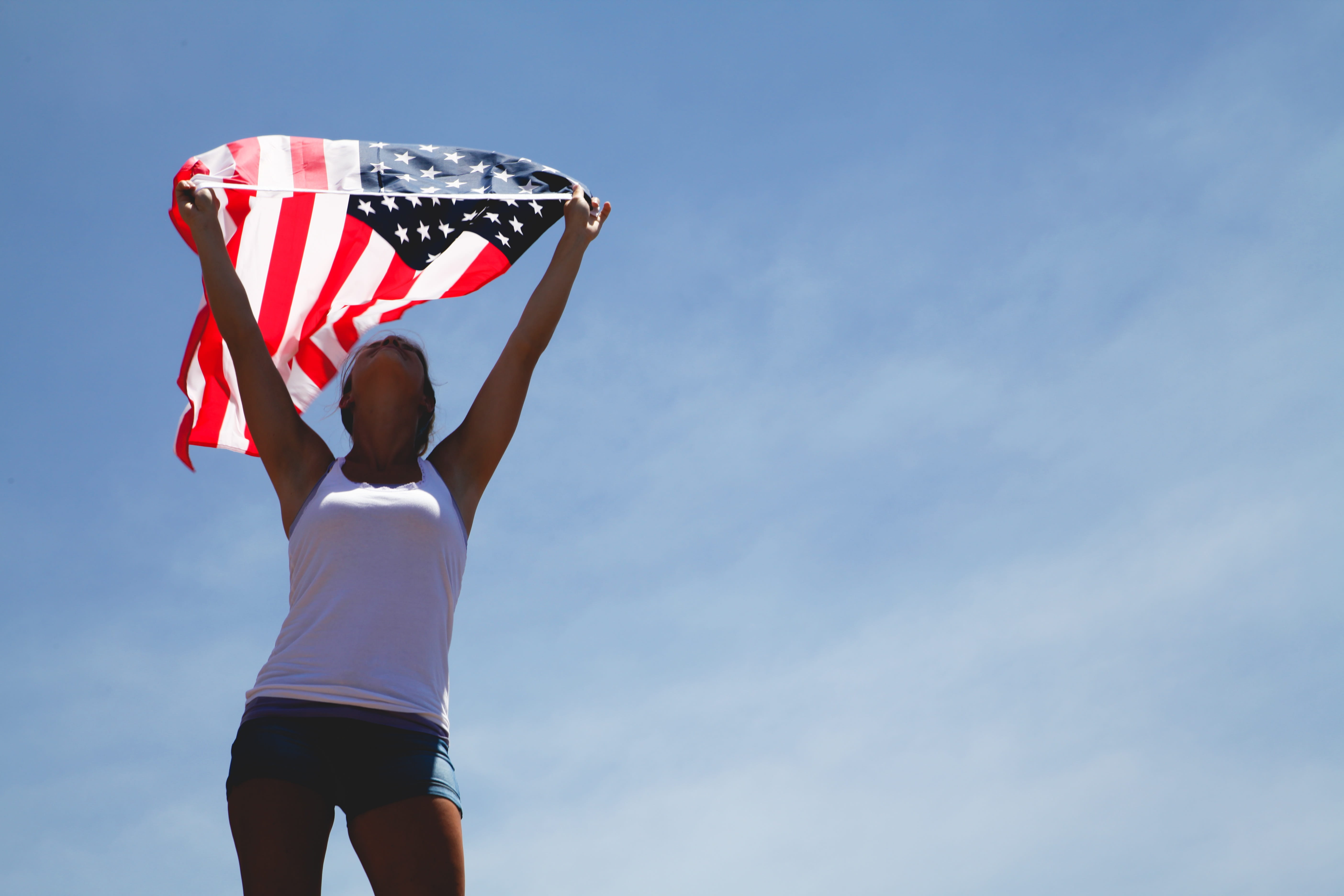 human limb, copy space, human body part, arms raised, blue, sunlight, 5K, sky, standing, lifestyles, flag, american flag, clothing, day, woman, one person, HD Wallpaper