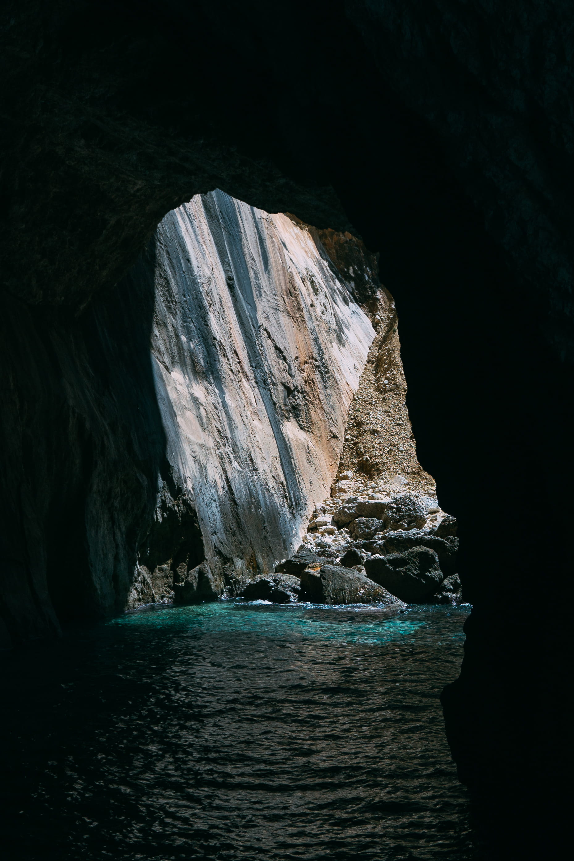 stone - Object, rocky stone, famous Place, cave, nature, paxo, stone, no People, sea, tourism, backlit, nature light, beach, europe, stone cliff, seascape, Phone HD Wallpaper