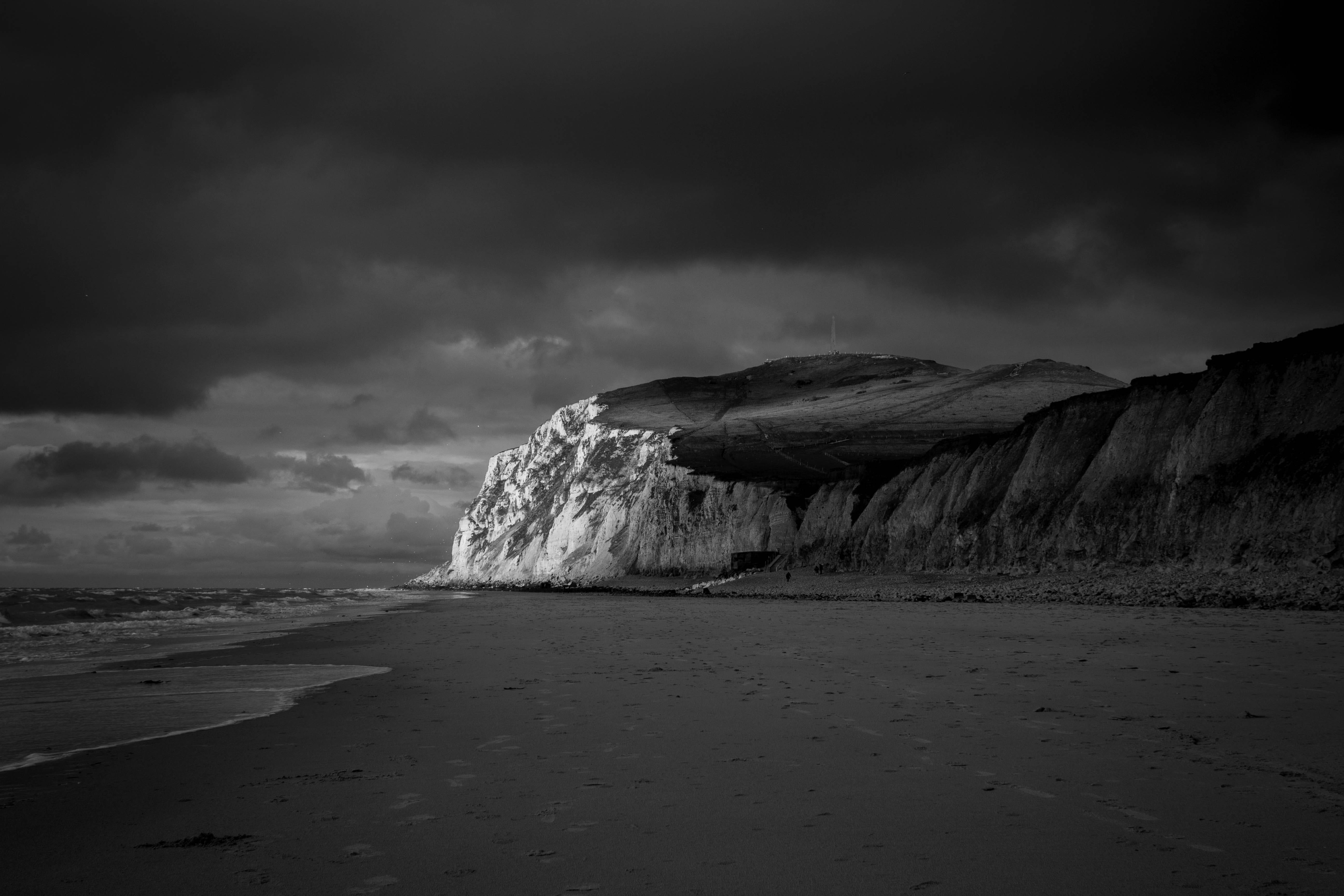 solid, dark, shore, black and white, outdoors, overcast, cloud - sky, sky, storm, clouds, water, cliff coast, waves, no people, rock, cloudy, rocks, near, HD Wallpaper