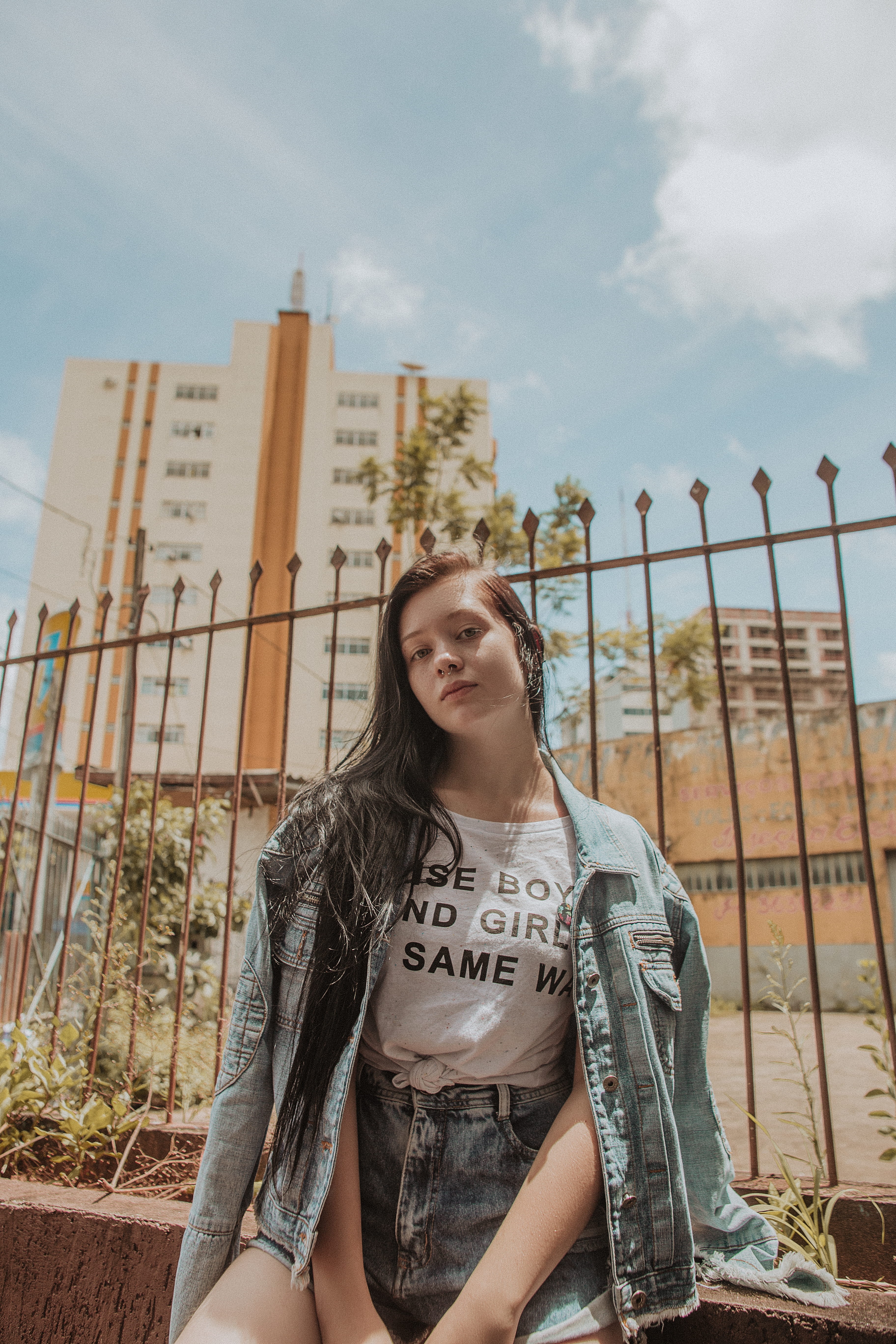 girl power, 5K, lifestyles, front view, cloud - sky, fence, life, eye contact, demin, female, near, building, long hair, young adult, three quarter length, Phone HD Wallpaper