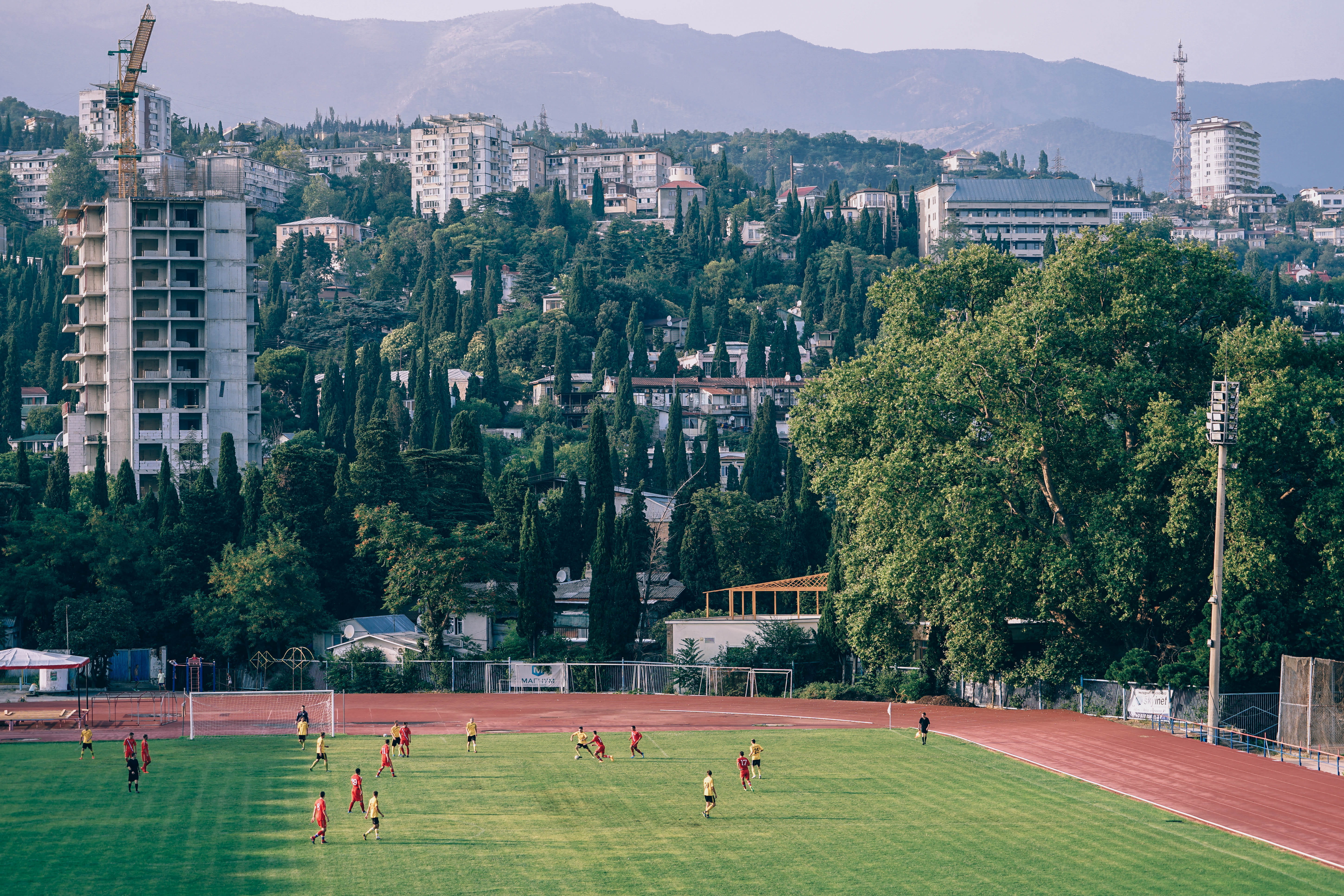built structure, lines, leisure activity, football game, athletes, large group of people, trees, post, day, clouds, city, ball, team sport, playing, real people, HD Wallpaper