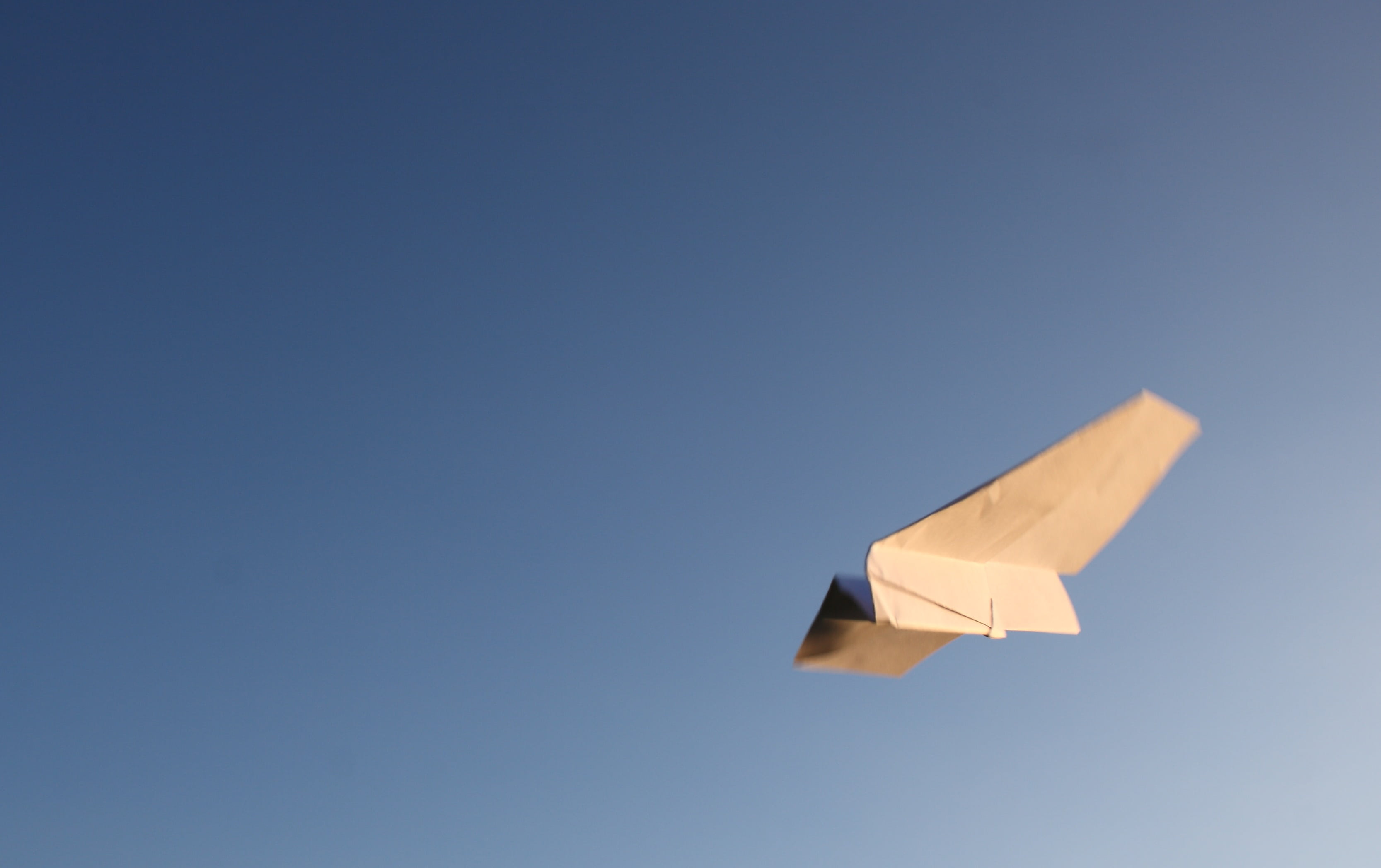 white, air vehicle, sky, photography, no people, 2K, play, folded, mid-air, paper, outdoors, airplane, letter, banner, single object, blue background, HD Wallpaper