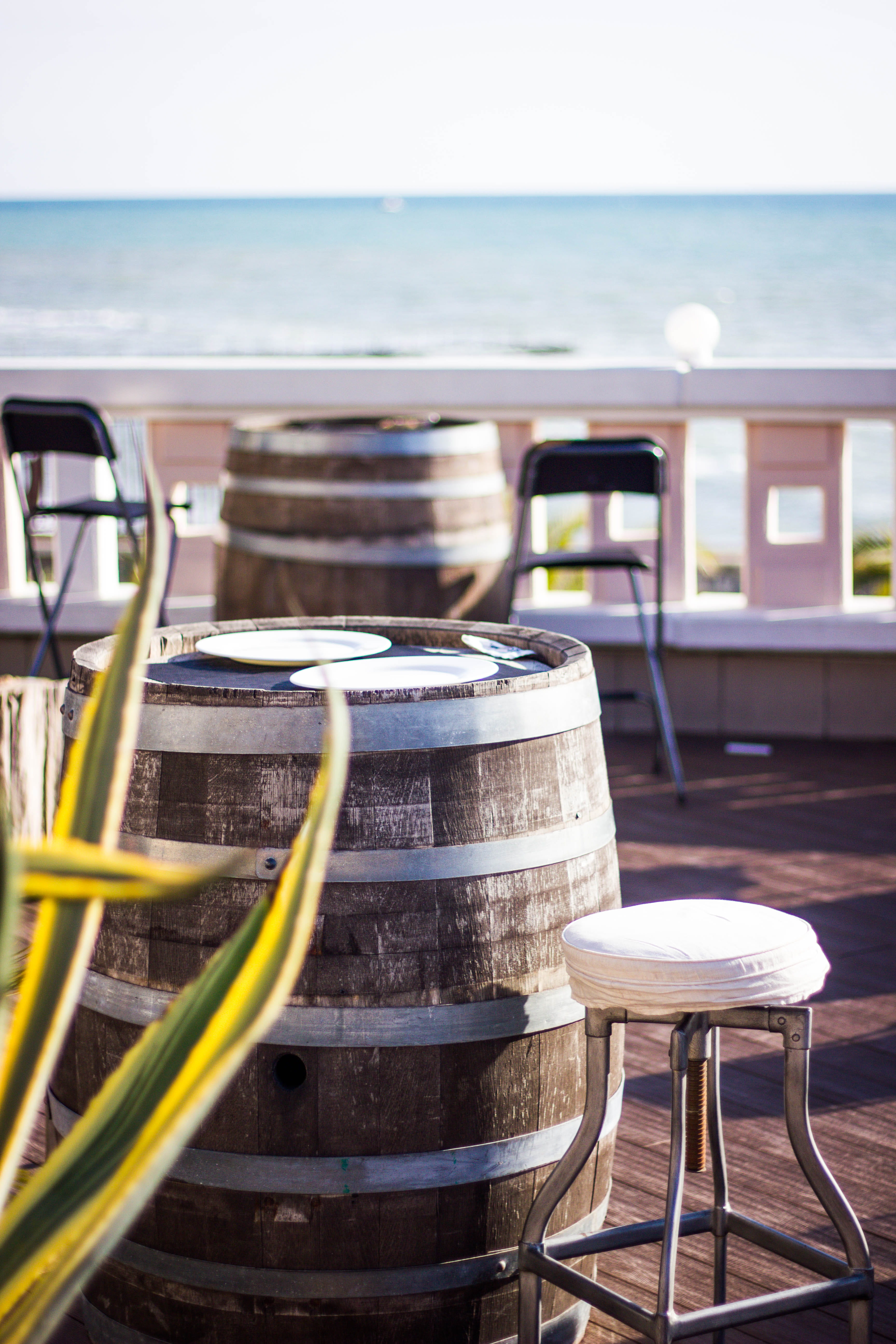 selective focus, wood - material, beach, water, no people, nature, travel, café, table, ceramic, keg, blur, barrel, sea, day, sky, seat, summer, plate, Phone HD Wallpaper